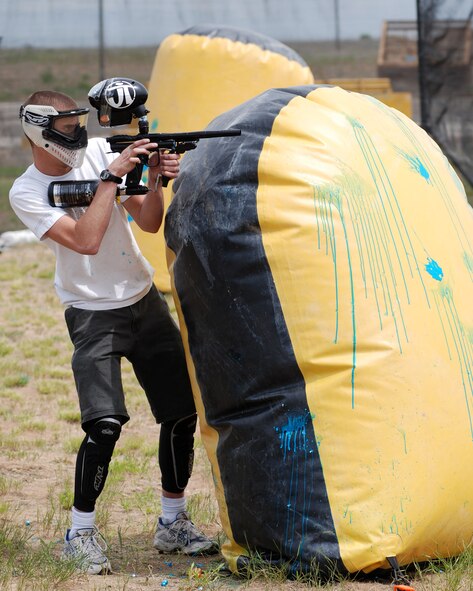 FAIRCHILD AIR FORCE BASE, Wash. -- Airman 1st Class Tom Morone, 92nd Services Squadron storeroom clerk, fires around an obstacle while playing speedball at the sports range here May 26. The intramural paintball season begins June 9. (U.S. Air Force photo/Tech. Sgt. Larry Carpenter) 