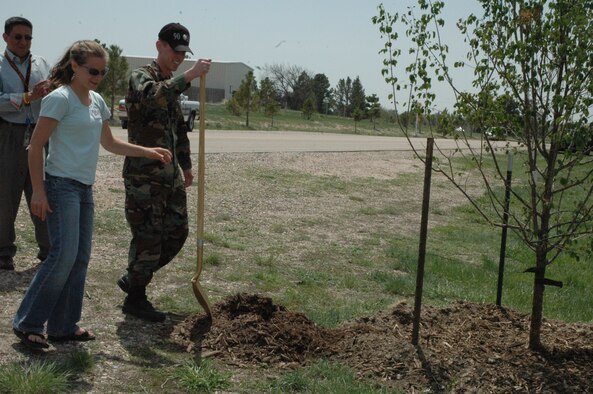 Maj. Thomas Taylor, 90th Civil Engineer Squadron chief of operations, prepares to throw the ceremonial first soil onto a newly planted tree in recognition of Arbor Day during the 90th CES Environmental Symposium at Pearson Lake May 16. This was Warren’s 18th year of celebrating the day. Students from Freedom Elementary School in Cheyenne attended the symposium that was aimed at educating children on environmental issues. Nellie Simon, Wyoming State Forestry District, and Tom Gonzales, 90th CES, were also part the tree presentation (Photo by Airman Alex Martinez).