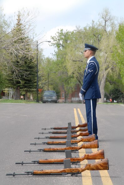Airman 1st Class Jason Moscoso, 790th Missile Security Forces Squadron, stands by the honor guard rifles during the 90th Security Forces Group retreat ceremony May 15 at the base flag pole. The retreat ceremony, held during National Law Enforcement Week, honored law enforcement personnel killed on duty (Photo by Shelley Raffl).