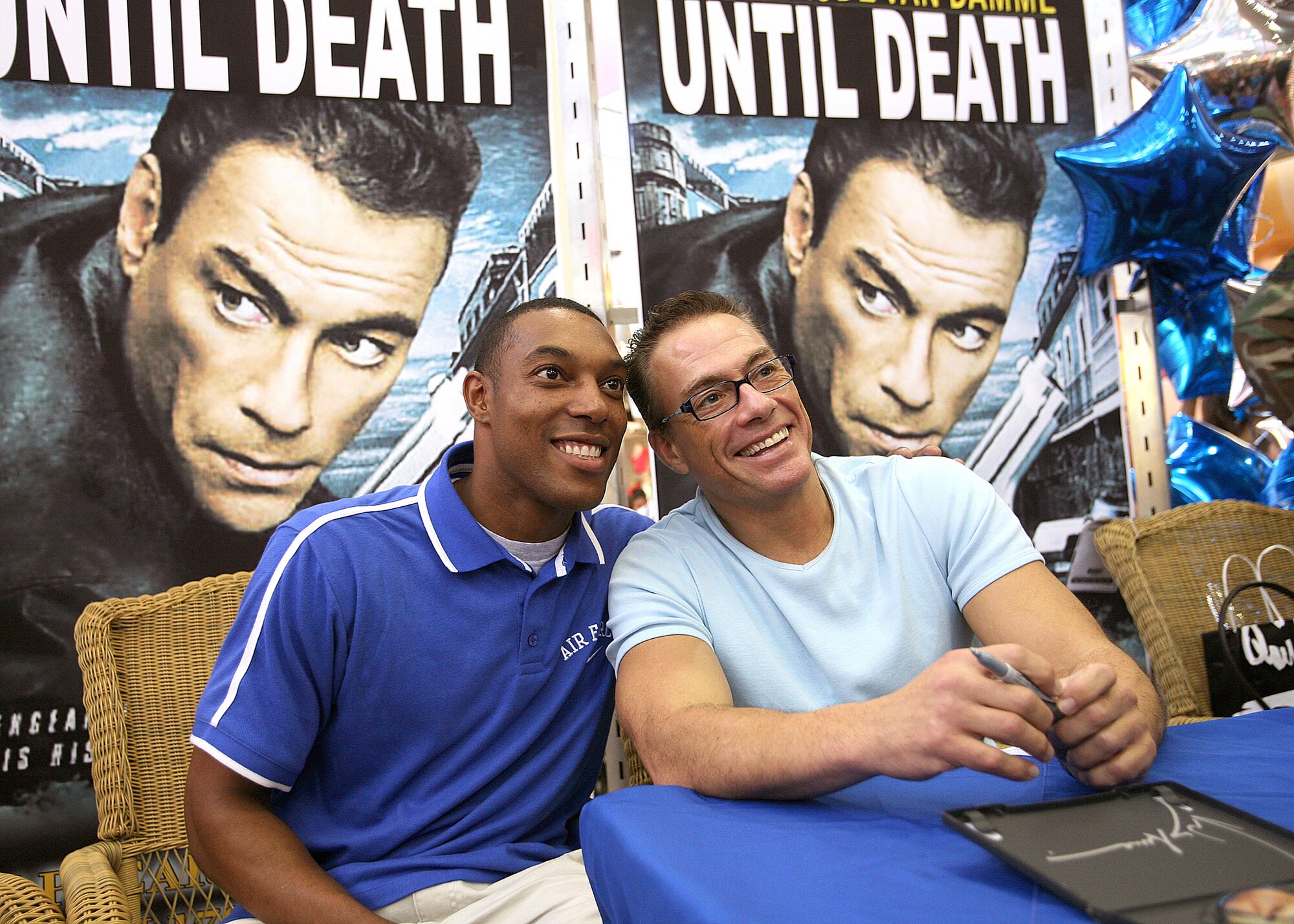 Airman 1st Class Joseph Langston poses for a picture with actor Jean-Claude Van Damme June 2 at the base exchange at Lackland Air Force Base, Texas. Mr. Van Damme signed autographs and posed for photos with base members. Airman Langston is a services technical training student with the 344th Training Squadron.  (U.S. Air Force photo/Robbin Cresswell)