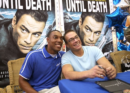 Airman 1st Class Joseph Langston poses for a picture with actor Jean-Claude Van Damme June 2 at the base exchange at Lackland Air Force Base, Texas. Mr. Van Damme signed autographs and posed for photos with base members. Airman Langston is a services technical training student with the 344th Training Squadron.  (U.S. Air Force photo/Robbin Cresswell)