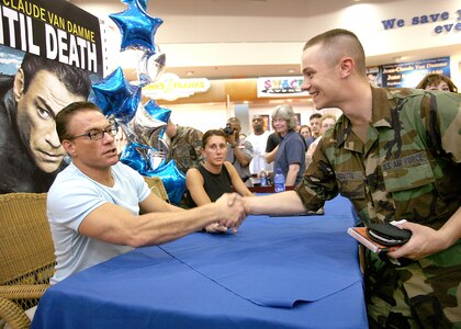 Airman Basic Jeffery Birdette shakes hands with actor Jean-Claude Van Damme June 2 at the base exchange at Lackland Air Force Base, Texas. Airman Birdette, a security forces technical training student at Lackland AFB, had a DVD autographed by Mr. Van Damme as he went through the line. (U.S. Air Force photo/Robbin Cresswell)
