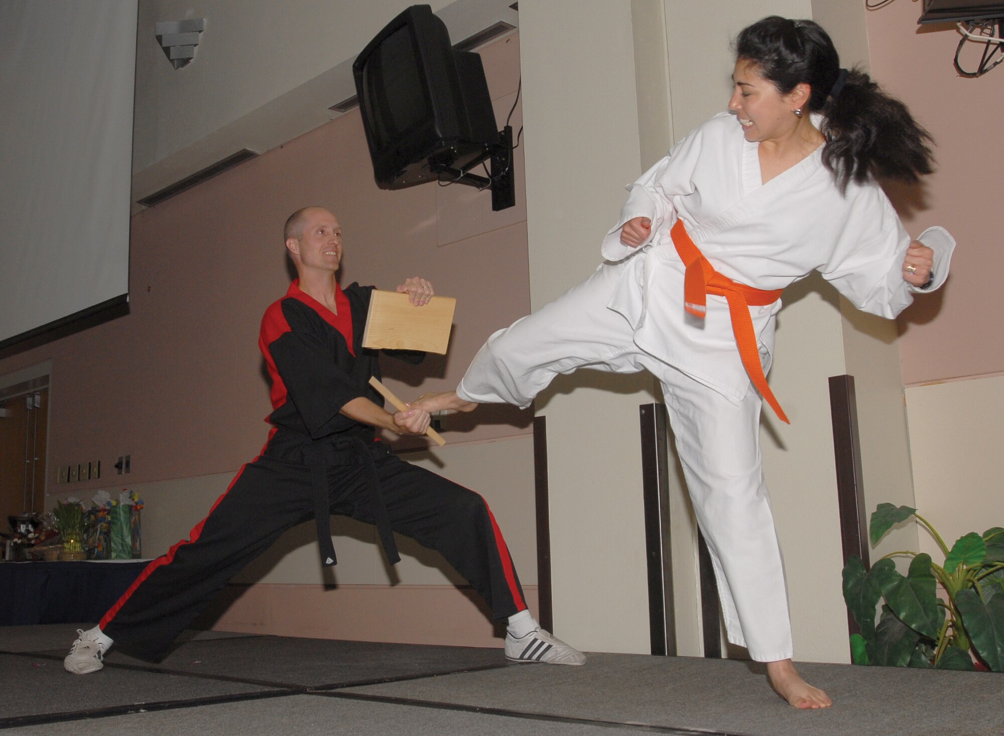 With a precise amount of force and direction, Staff Sgt. Jenny Tuckett of the 316th Training Squadron splits a block of wood with a kick while Michael Sekach of Choi’s Tae Kwon Do holds on. The breaking of the wood blocks was part of a martial arts demonstration performed during the 2007 Asian / Pacific Islander Heritage Luncheon, held Tuesday at the Goodfellow Events Center. (U.S. Air Force photo by Staff Sgt. Angela Malek).