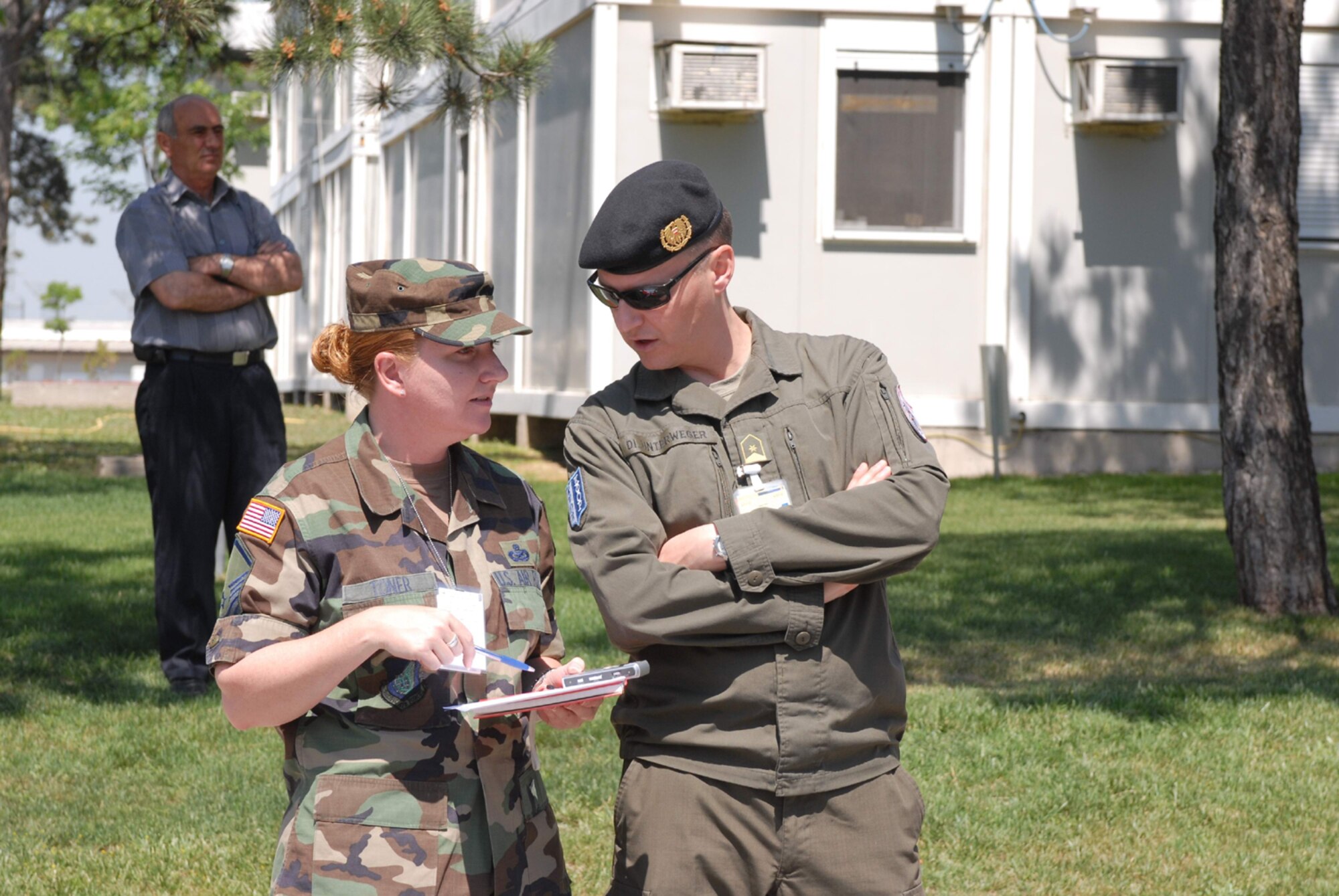 PRISTINA, KOSOVO -- Master Sgt. Cheryl Toner, deployed from Spangdahlem Air Base, Germany, talks to her supervisor, Austrian Army Major Alexander Unterweger, during an official ceremony in “Film City,” Pristina, Kosovo. The U.S. has been involved in the NATO-led operation since 1999. (Photo by Armend Aqifi)