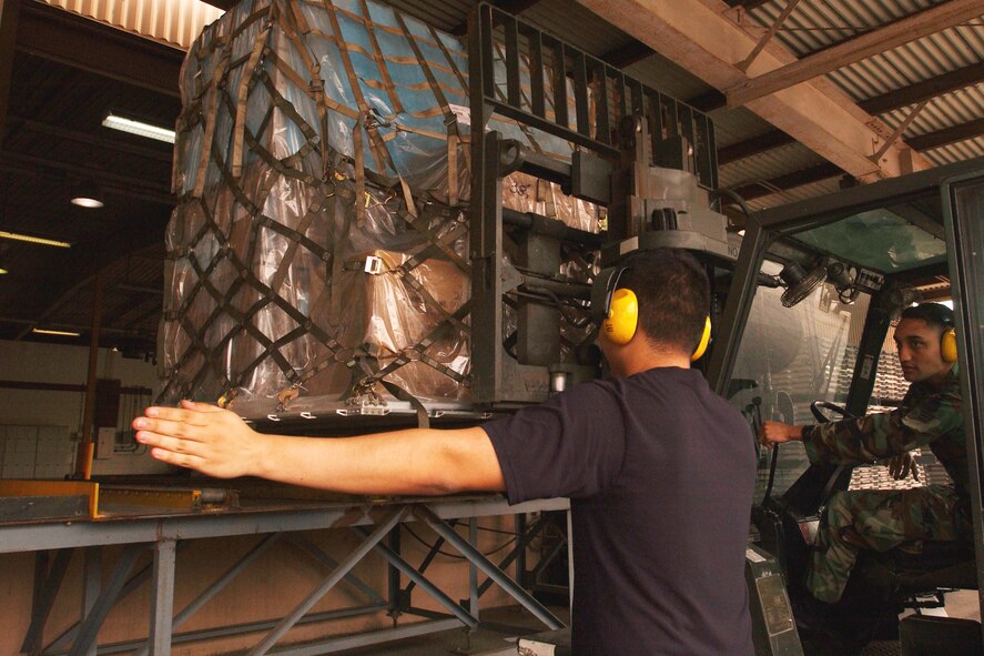 OSAN AIR BASE, Republic of Korea -- Senior Airman Cesar Martinez guides Senior Airman Christopher Johnson to the loading dock at the 731st Air Mobility Support Squadron cargo handling section here today. Airmen Martinez and Johnson are air transportation specialists with the 731st AMSS. (U.S. Air Force photo by Airman Jason Epley)