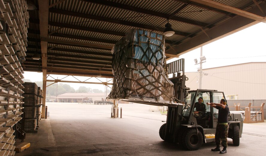 OSAN AIR BASE, Republic of Korea --  Senior Airman Cesar Martinez guides Senior Airman Christopher Johnson to the loading dock at the 731st Air Mobility Support Squadron cargo handling section here today. Airmen Martinez and Johnson are air transportation specialists with the 731st AMSS. (U.S. Air Force photo by Airman Jason Epley)