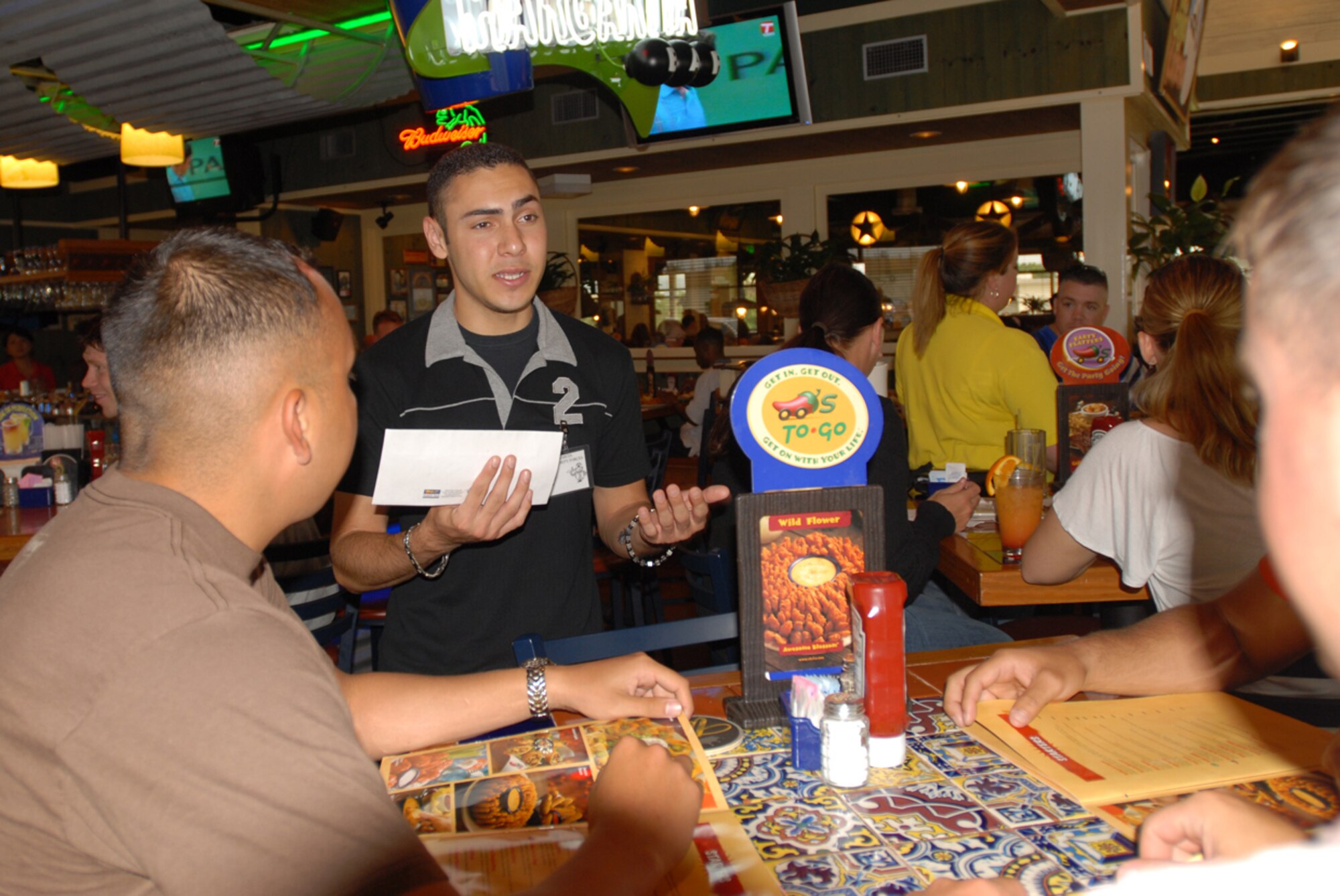 Airman 1st Class Joshua Garcia, 18th Security Forces Squadron, talks to customers at Chili’s on Kadena Air Base, Japan, about giving donations to Special Olympics during the “Tip-a-Cop” fundraiser June 2. Airman Garcia was one of 42 military police members from all branches of service to volunteer for the event that raised more than 2,500 dollars.
(U.S. Air Force/Airman 1st Class Kasey Zickmund)