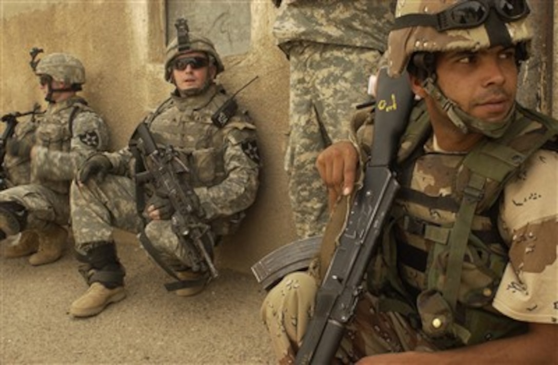 Iraqi army and U.S. Army soldiers takes a break while pulling security during a building clearing mission in Rashid, Iraq, on June 2, 2007.  The U.S. soldiers are attached to Alpha Company, 2nd Battalion, 3rd Infantry Regiment.  