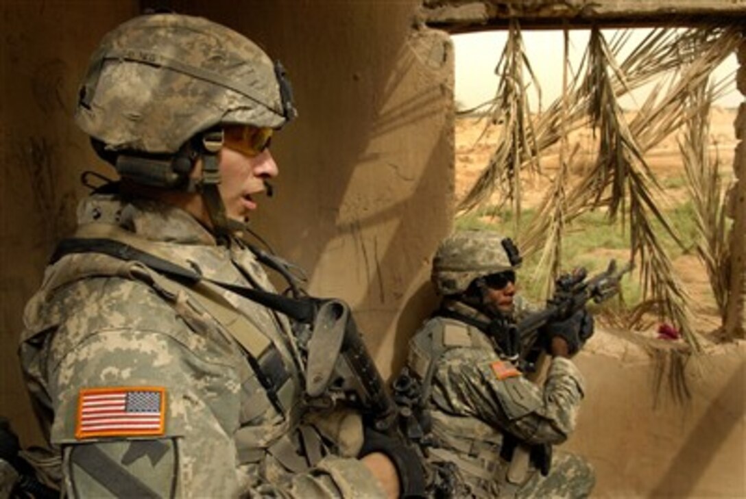 U.S. Army Staff Sgt. Richard Wilson (left) maintains communications while Sgt. Antwon Monroe provides security during a mission near Baqubah, Iraq, on June 2, 2007. Wilson and Monroe are from Charlie Company, 1st Battalion, 12th Cavalry Regiment.  