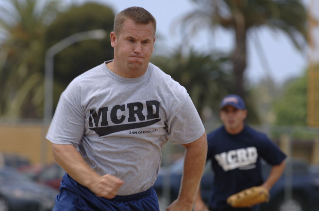 Coast Guard Petty Officer 2nd Class Steven Malicki, runs to the next base as a teammate hits the ball.