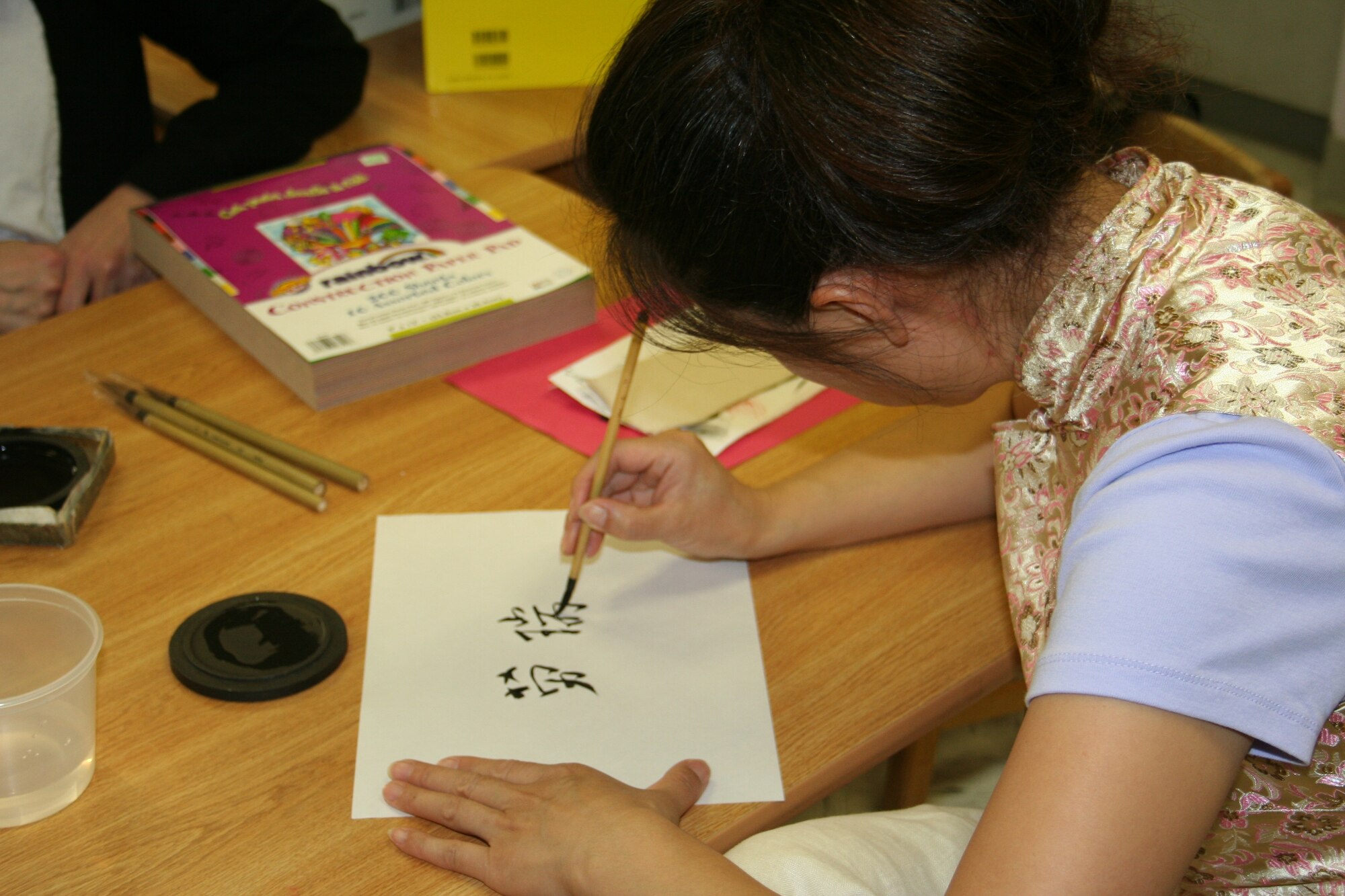 Anne Tull, spouse of Capt. Daniel Tull, demonstrates how to write children’s names in Chinese.

The Child Development Center, along with the Parent Advisory Board, held Parent Literacy Night for all families enrolled in the center.  Activities centered on how parents can promote literacy for children ages 6 weeks to 5 years. (Photo courtesy of Samantha Jacobs)
