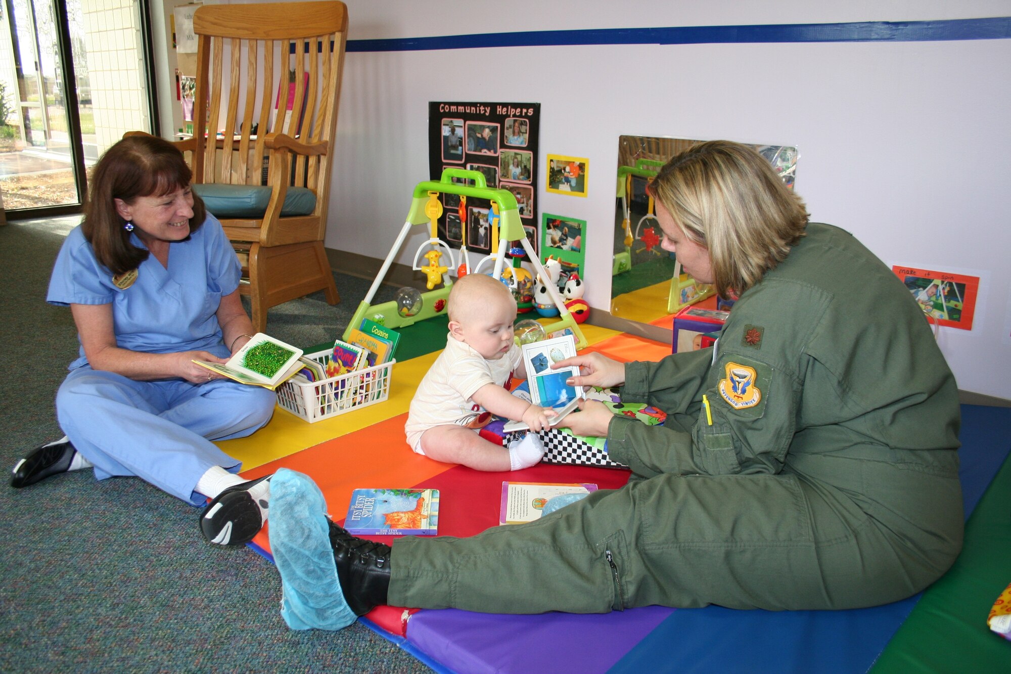 Maj. Jennifer Avery, 509th Operational Support Squadron, with the help of caregiver Shirley Witt, shows her son Avery  a book to teach him the basics of reading.

The Child Development Center, along with the Parent Advisory Board, held Parent Literacy Night for all families enrolled in the center.  Activities centered on how parents can promote literacy for children ages 6 weeks to 5 years. (Photo courtesy of Samantha Jacobs)
