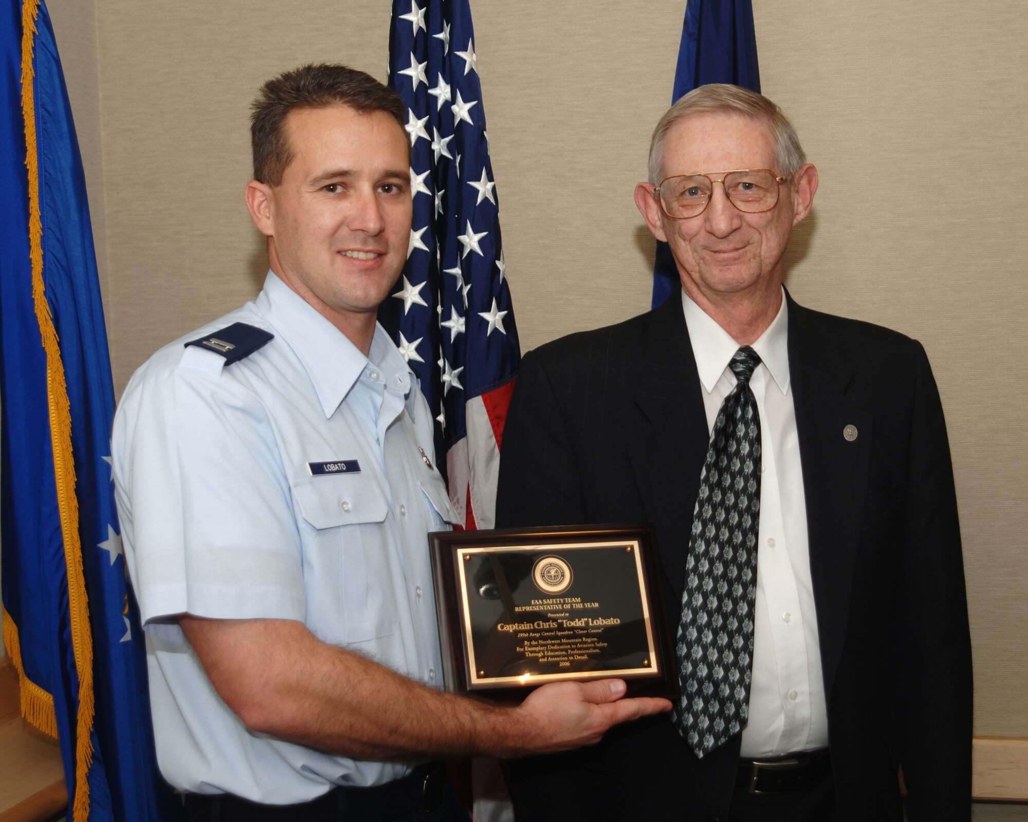 Capt. Todd Lobato, chief air traffic control training officer for the Utah Air National Guard's 299th Range Control Squadron, is honored as the Federal Aviation Administration's Regional Safety Team Representative of the Year.  Bryan Neville of the FAA makes the presentation.  (Air Force photo/Staff Sgt. Michael Ormond)