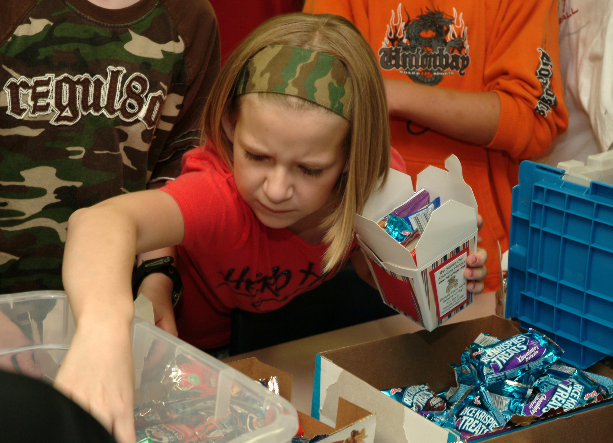 EGLIN AIR FORCE BASE, Fla. -- Bailey Reese, Longwood Elementary 5th grader, reaches to collect more goodies to stuff into her patriotic decorated oriental food to-go box to send to deployed Airmen. The 11-year-old is the founder and president of America Supports You grassroots organization, Hero Hugs. Ms. Reese, her classmates and Airmen from the 53d Wing, worked together to fill more than 300 boxes to be shipped to Iraq and Afghanistan. She was just named the 2007 Real American Girl of the Year by American Girl. Her organization, Hero Hugs, will receive a $5,000 donation to help with future packages and her school will also get a $5,000 donation from American Girl. (U.S. Air Force photo/Tech. Sgt. Andrew Leonhard)