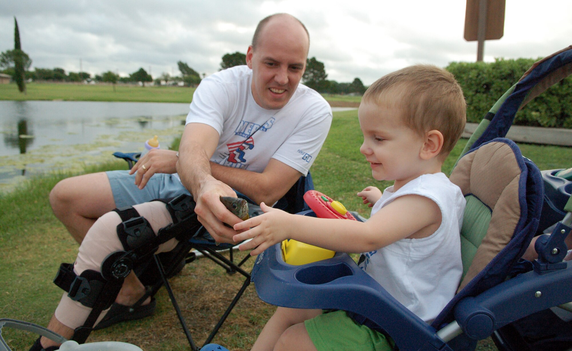 LAUGHLIN AIR FORCE BASE, Texas -- Senior Airman Daniel Beug, 47th Communications Squadron, lets his son Dennis, 22 months, examine the first fish he’s ever caught.  (U.S. Air Force photo by Staff Sgt. Austin M. May)