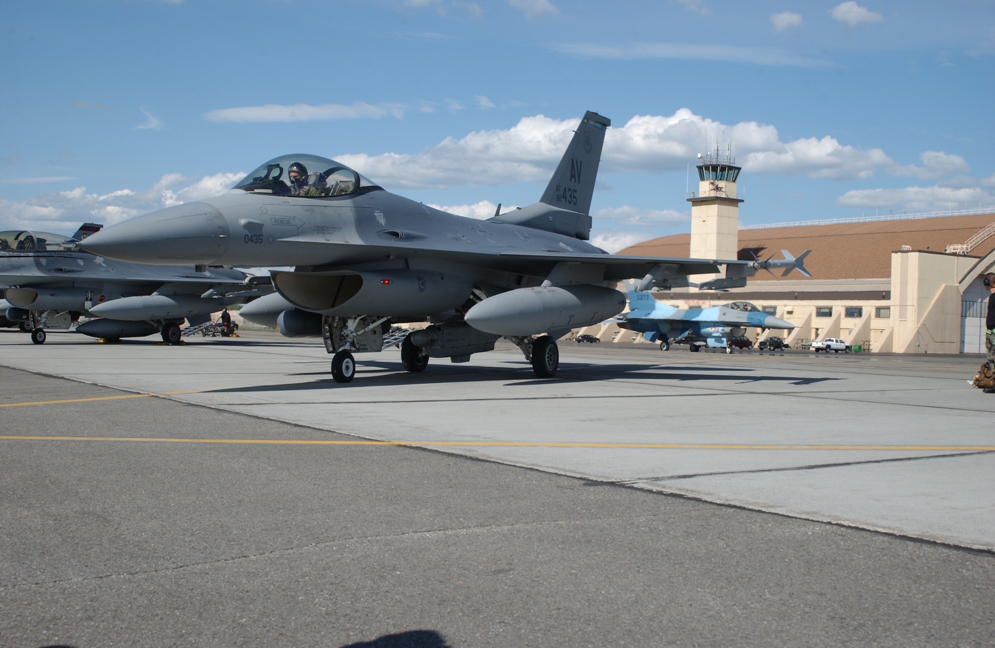 EIELSON AIR FORCE BASE, Alaska -- An F-16 Fighting Falcon, 64th Aggressor Squadron, Nellis AFB, Nev., taxis between an F-16 from the 555th Fighter Squadron, Aviano Air Base, Italy, and the Thunderdome during Red Flag-Alaska 07-2 June 4 here. RF-A 07-2 is a Pacific Air Forces-directed field training exercise for U.S. and coalition forces flown under simulated air-combat conditions. It is conducted on the Pacific Alaska Range Complex with air operations flown out of Eielson and Elmendorf Air Force Bases. (U.S. Air Force Photo by Airman 1st Class Jonathan Snyder) 
