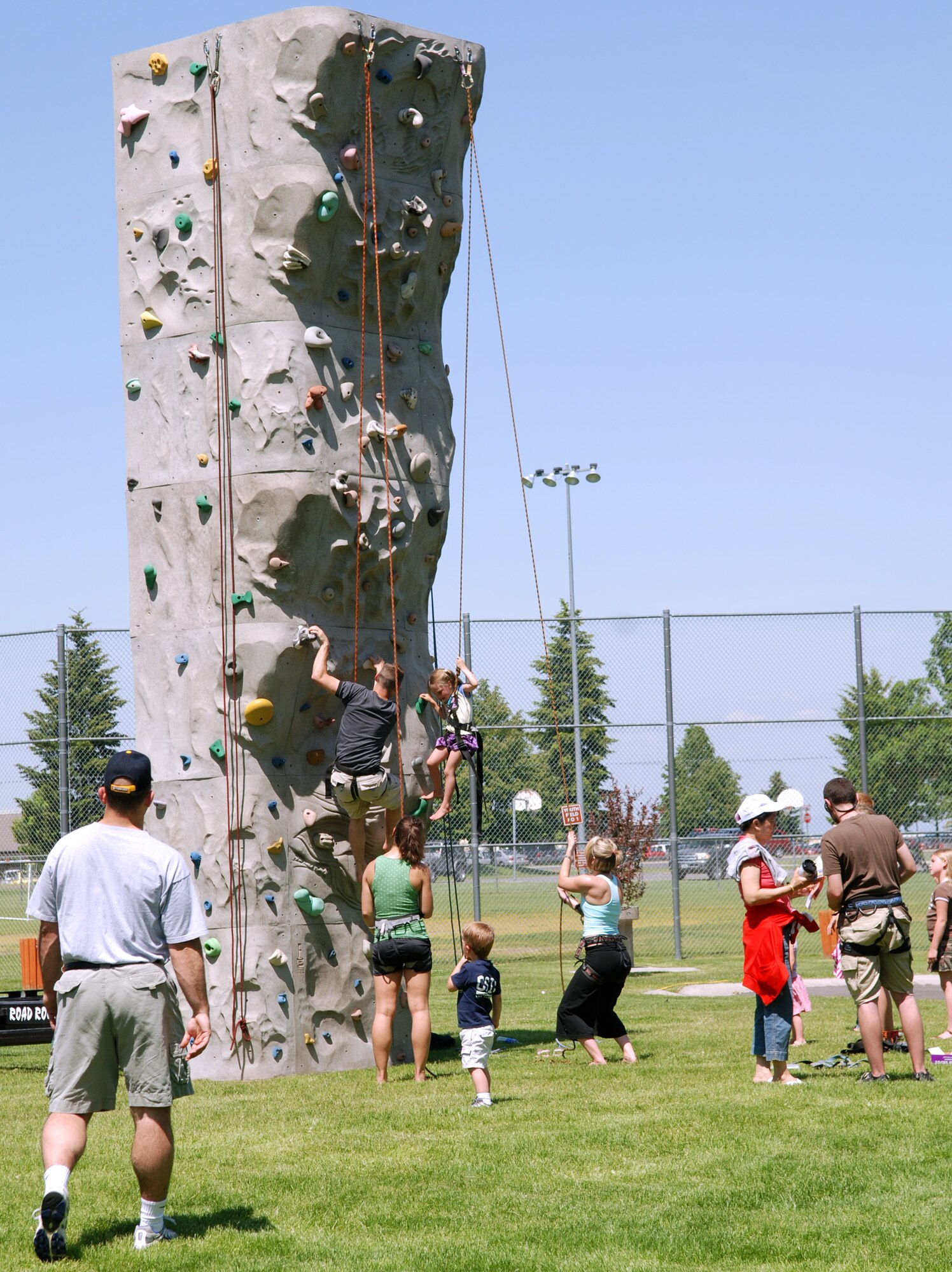 FAIRCHILD AIR FORCE BASE, Wash. -- Wing MatchUP picnic participants gather around the Wild Walls mobile climbing wall, waiting to participate and watching the two climbers already on their way up. The climbing wall was one of the attractions at the picnic that drew many participants. (U.S. Air Force photo/ Tech. Sgt. Larry Carpenter)