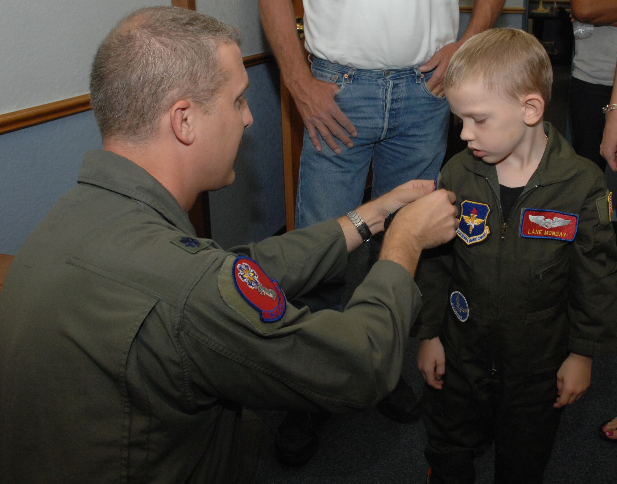 Lt. Col. Paul Bauman, 58th Airlift Squadron commander, gives Lane Monday his official 58th AS patch to go with his flight suit during the Pilot for a Day program tour. (U.S. Air Force photo/Senior Airman Mercedes Crossland)