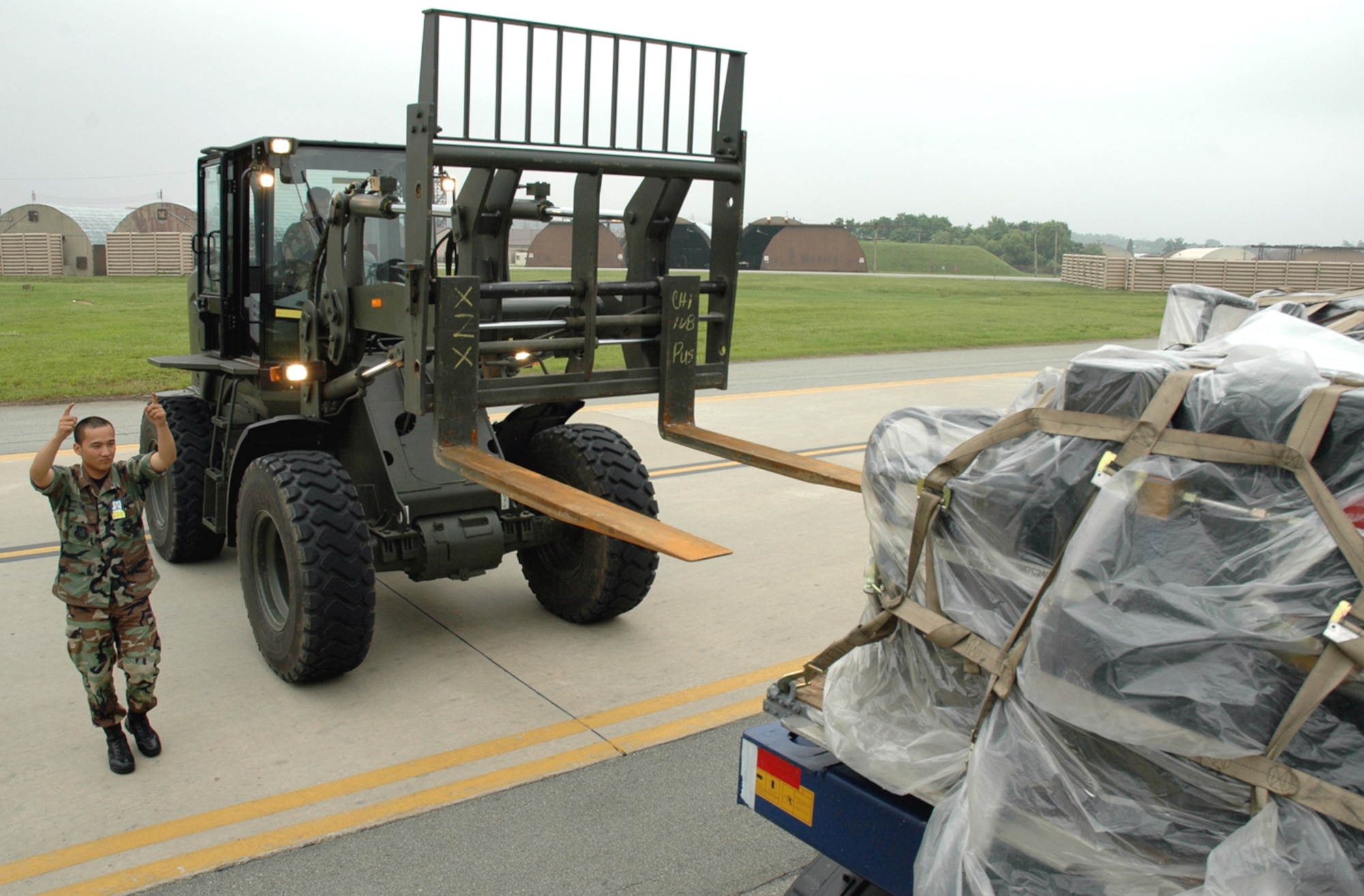 OSAN AIR BASE, Republic of Korea --  Senior Airman Chantana Sine helps direct Senior Airman Johnny Roland while unloading supplies for the 36th Fighter Squadron here Tuesday. Both Airmen are with the 51sts Logistics Readiness Squadron. (U.S. Air Force photo by Staff Sgt. Benjamin Rojek)