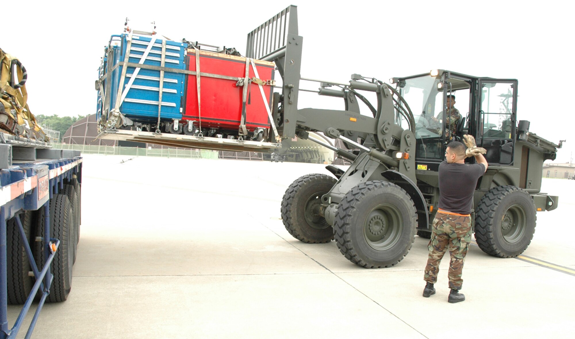 OSAN AIR BASE, Republic of Korea --  Senior Airman Rafael Bernal helps direct Airman 1st Class Rudy Garcia while unloading supplies for the 25th Fighter Squadron here Tuesday. Both Airmen are with the 51st Logistics Readiness Squadron. (U.S. Air Force photo by Staff Sgt. Benjamin Rojek)