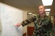 Tech. Sgt. James Black explains a schematic of the 13th Air Force Contracting Division’s mission essential tasks.  USAF Photo by Capt. Yvonne Levardi.