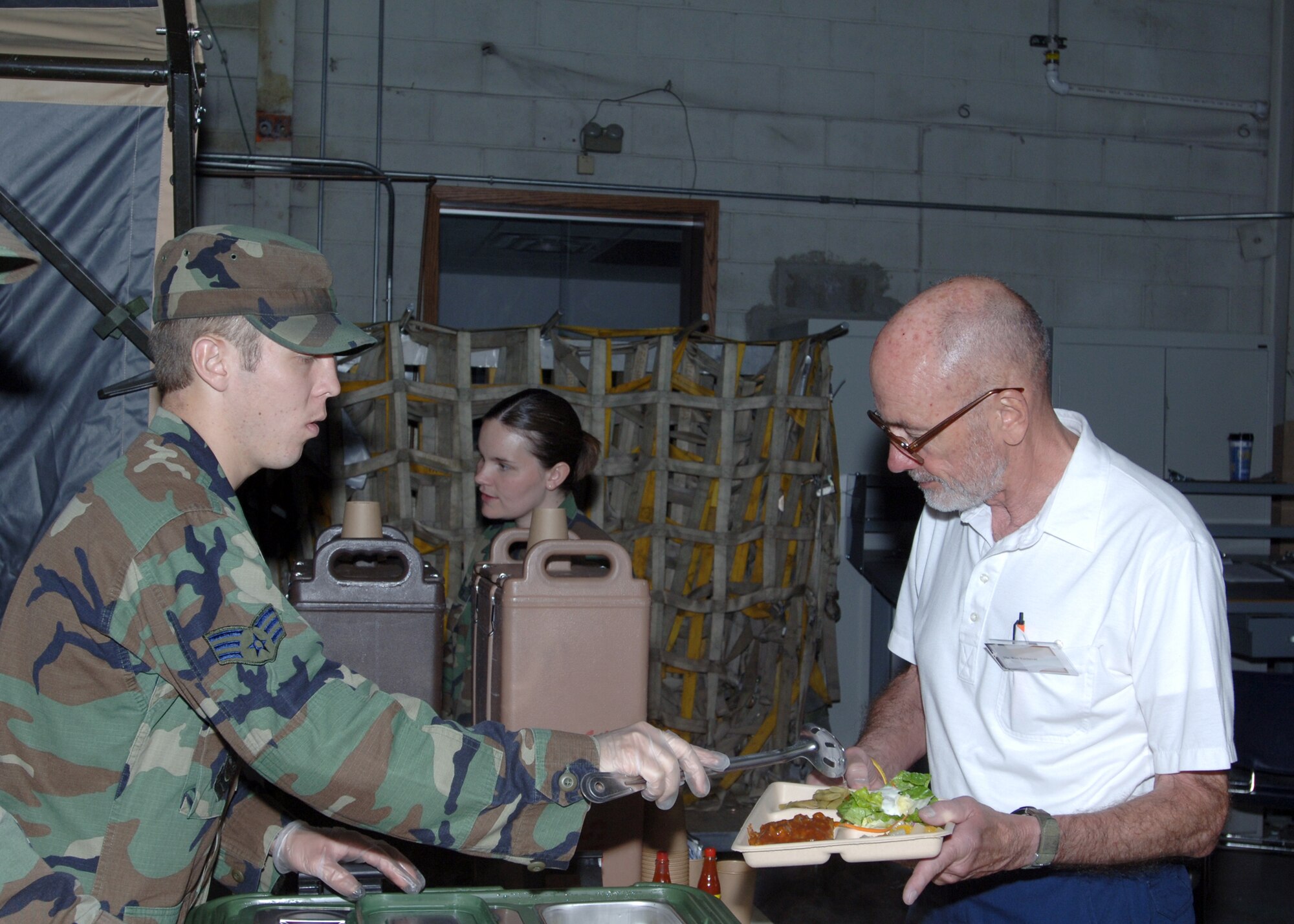 SrA Jacob Casey, 319th Mission Support and Services, serves Ron Kochevar lunch from a field kitchen. Mr. Kochevar is a member of the Golden Eagles Club, a division of the Grand Forks, East Grand Forks Chamber of Commerce’s Military Appreciation Committee. (U.S. Air Force photo/Staff Sgt. Suellyn Nuckolls)