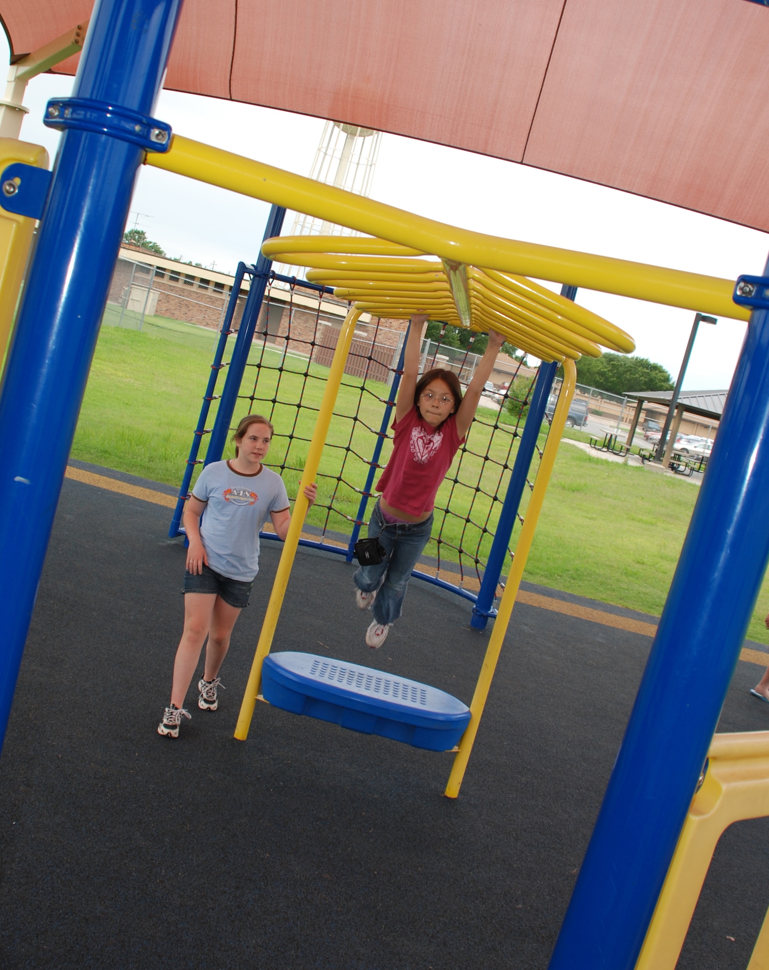 Emili Futagawa swing on the monkey bars at the Madrigal Youth Centers summer camp June 5. (U.S. Air Force photo/Airman 1st Class Jacob Corbin)