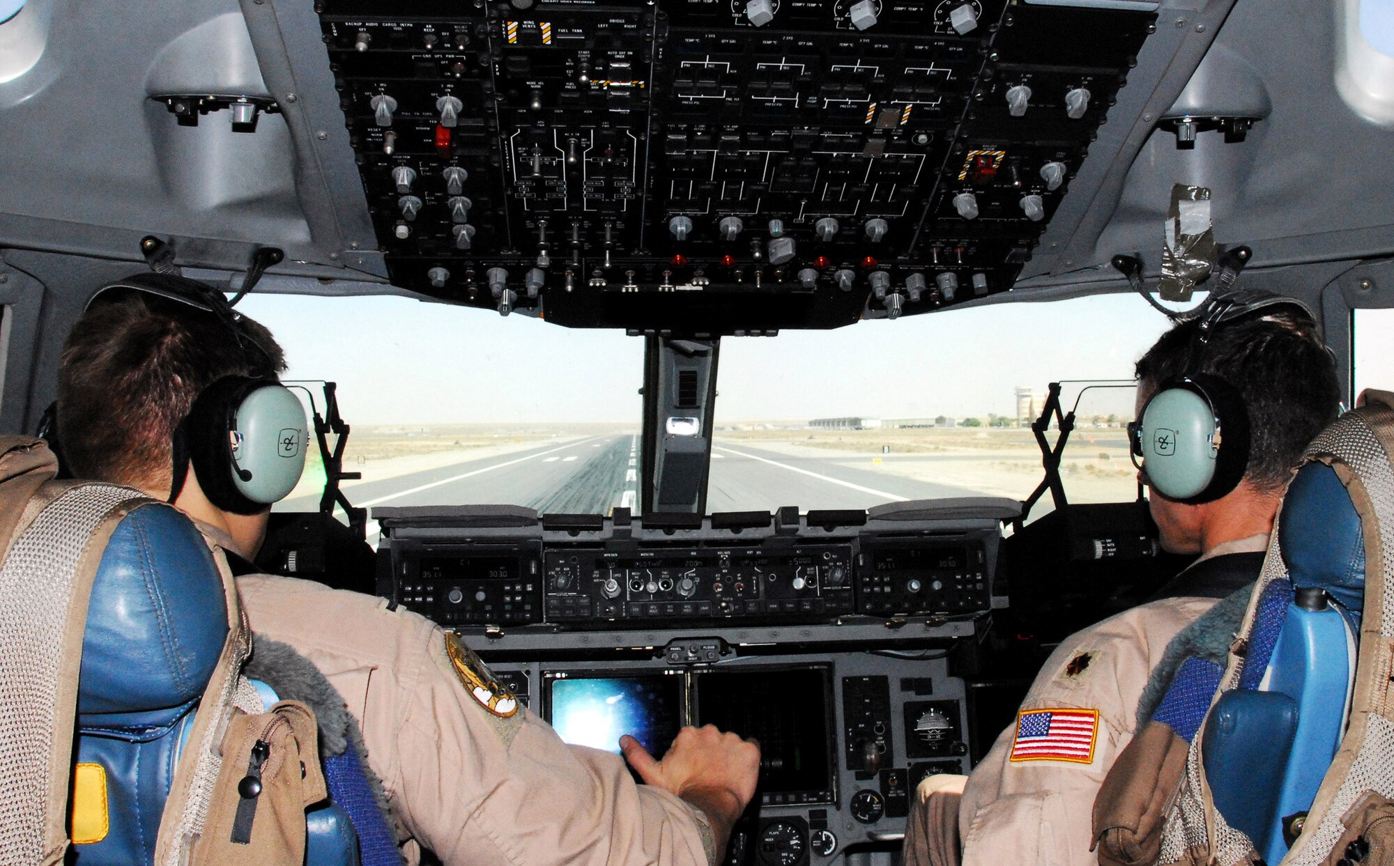 C-17 Globemaster III pilots 1st Lt. Brad Lane (left) and Maj. Scott Berndt prepare to depart from a forward operating location June 6 carrying passengers to another location in the area of responsibility.  Coalition C-17s and C-130 Hercules moved 1,960 passengers and delivered more than 1.4 million pounds of cargo June 5.  The two pilots are assigned to the 816 Expeditionary Airlift Squadron. (U.S. Air Force photo/Tech. Sgt. Scott Moorman) 