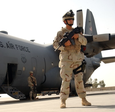 Airman 1st Class Patrick Dantzic, 332nd Expeditionary Security Forces Squadron, provides security for a C-130 Aircraft transiting to Balad Air Base, Iraq as Senior Airman Gerald Mares, flyaway security team leader, provides over watch.  Airman Dantzic, a flyaway security team member, stood tall among his peers after scoring 96 percent in his career developmental course’s end-of-course test despite the hostility of his environment.  Airmen Dantzic and Mares are security forces members assigned to the 332nd ESFS, and they are deployed from Royal Air Force Mildenhall, United Kingdom.  (U.S. Air Force photo by Senior Airman Olufemi A. Owolabi)
