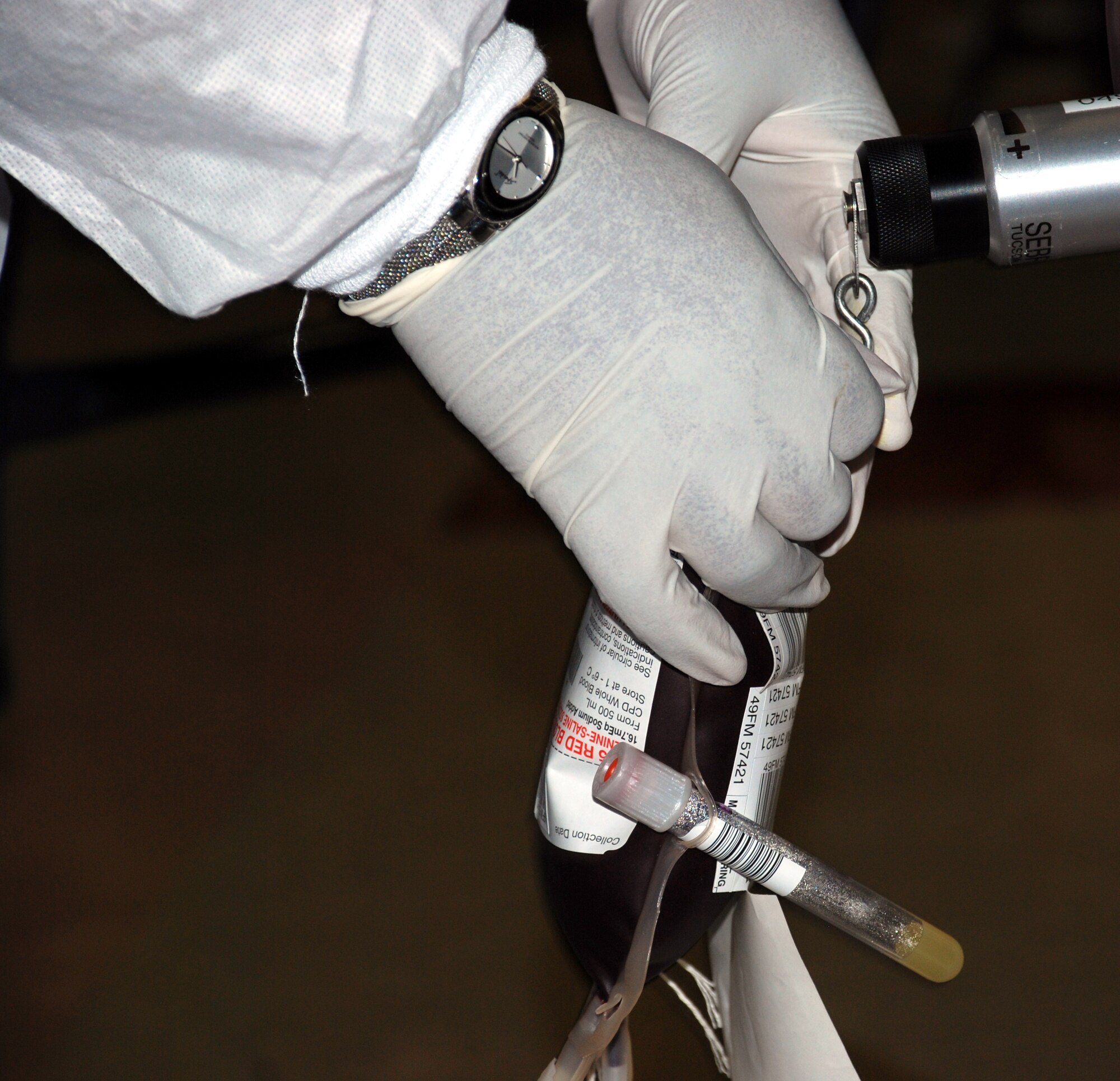 A phlebotomist with the Red Cross inspects a unit of donated blood at the blood drive June 5. (U.S. Air Force photo/Airman 1st Class Jacob Corbin)