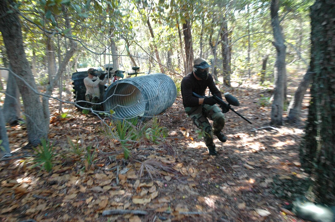EGLIN AIR FORCE BASE, Fla. -- Senior Airman Brendan Harms, 96th Security Forces Squadron investigator, races to find cover as members of his team provide cover fire during a game of paintball against students from the Youth Center June 5. They kicked off a summer-long campaign June 5 by taking some of the older students from the Eglin Youth Center to the paint ball fields at Hurlburt Field for a game or two of paintball assault on each other. The investigations Airmen want to curb mischievous behavior in adolescents on base by becoming their mentors before those acts become criminal in nature. (U.S. Air Force photo by Staff Sgt. Mike Meares)