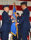 MINOT AIR FORCE BASE, N.D. -- Lt. Gen. Robert J. Elder Jr., 8th Air Force commander (left), hands off command of the 5th Bomb Wing to Col. Bruce Emig in a change of commander ceremony here June 5. Col. Emig assumed command of the wing from Col. Eldon A. Woodie, who retired the same day after 29 years of military service.