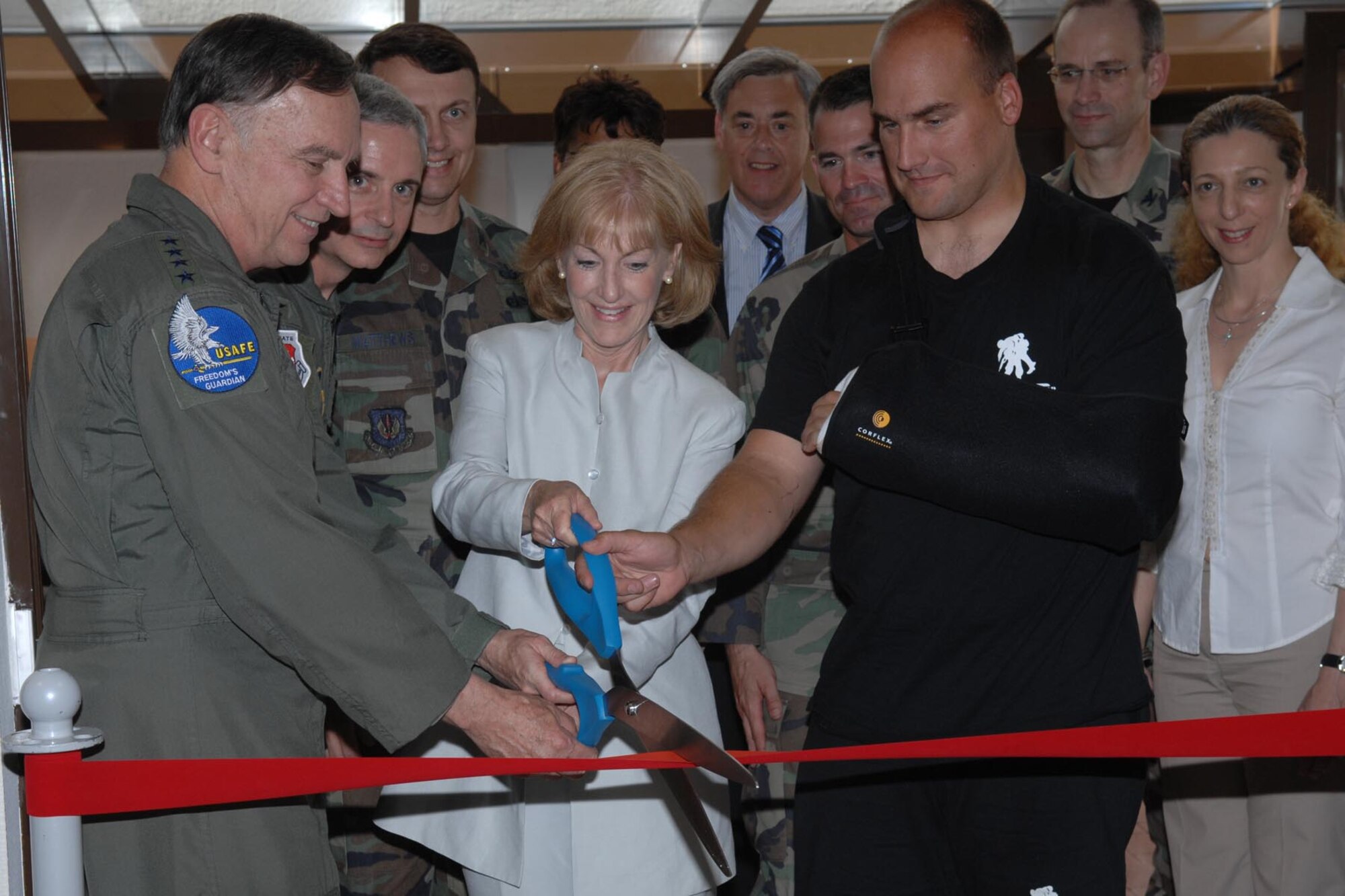 Gen. Tom Hobbins, U.S. Air Forces in Europe commander, helps cut the ribbon to the new USO center in the Contingency Aeromedical Staging Facility. The USO recently more than doubled its space within facility, which provides care and support for pateints flown into Ramstein from Iraq, Afghanistan and other areas. (U.S. Air Force photo/Senior Airman Erin Peterson)