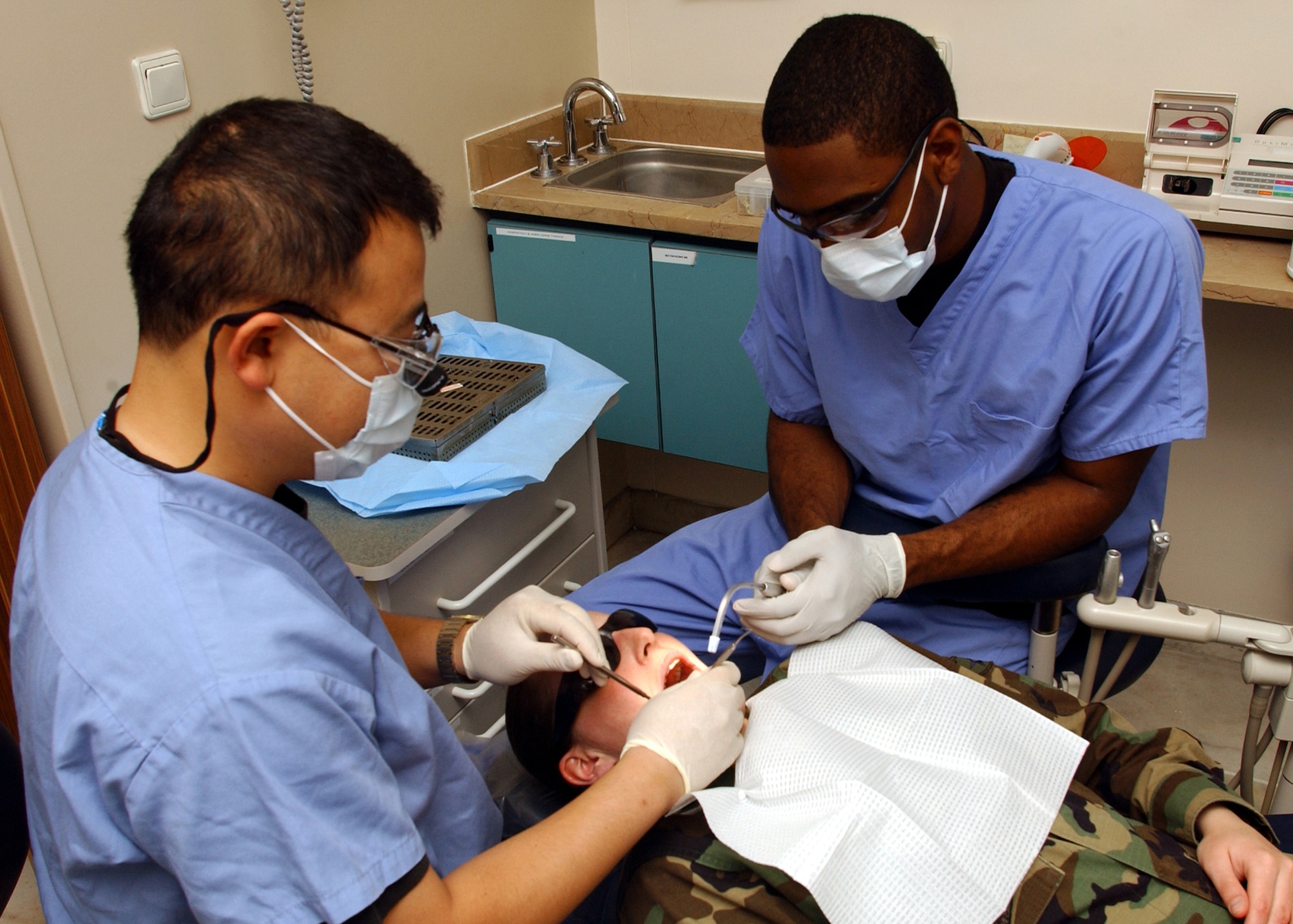 Major Son Vu (left) and SrA Jason Skerritt (right) 39th Medical Group perform a standard check up on SrA Kelly Zaiser 39th Medical Group in incirlik's dental Clinic, 17 May. Routine checkups are curtail to ensure all Airmen are deployment ready. (U.S. Air Force photo by Airman First Class Timothy A. Taylor)