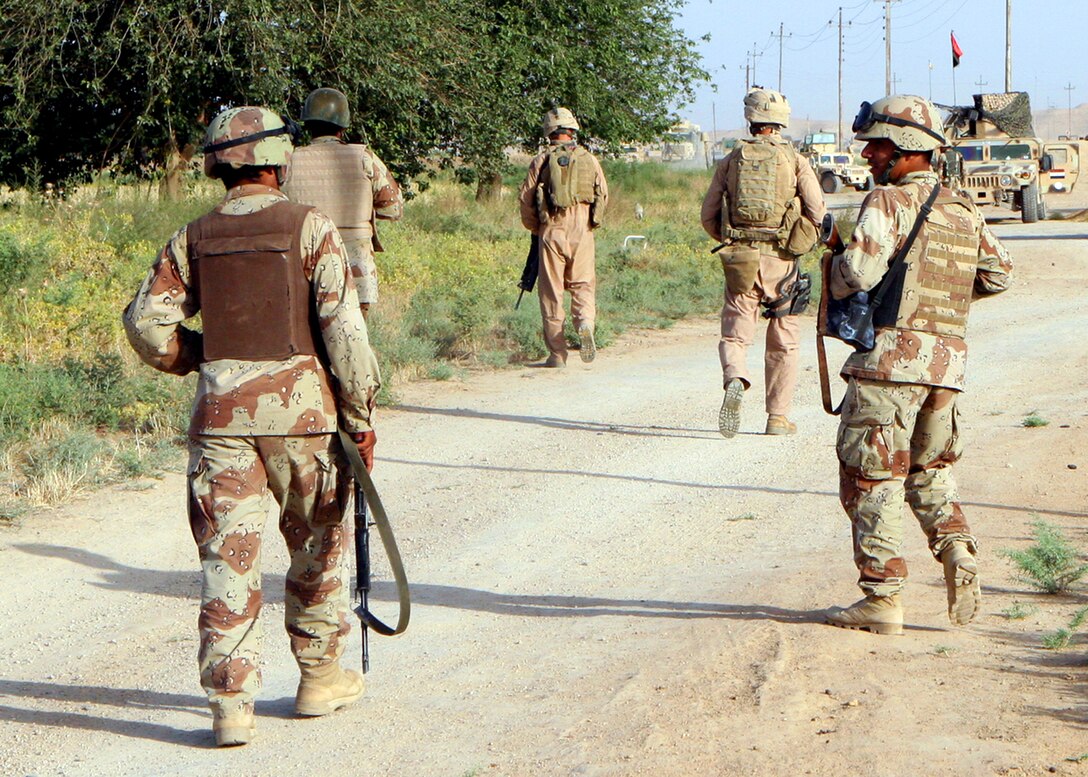 IBRAHIMIYAH PENINSULA, Iraq- Iraqi Army soldiers and Marines with Weapons Company, Task Force 1st Battalion, 4th Marines, Regimental Combat Team 2, move toward their vehicles to search another town along the border of TF 1/4?s and 1st Light Armored Reconnaissance?s areas of operation.  The operation secured towns not normally searched by the two battalions.