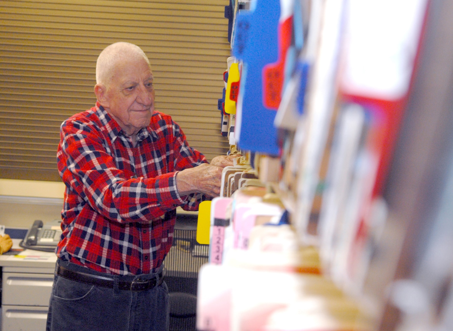 Buck Zehringer, a retired master sergeant who volunteers at the Randolph Dental Clinic, processes and prepares dental records for staff members each morning. (U.S. Air Force photo by Rich McFadden)