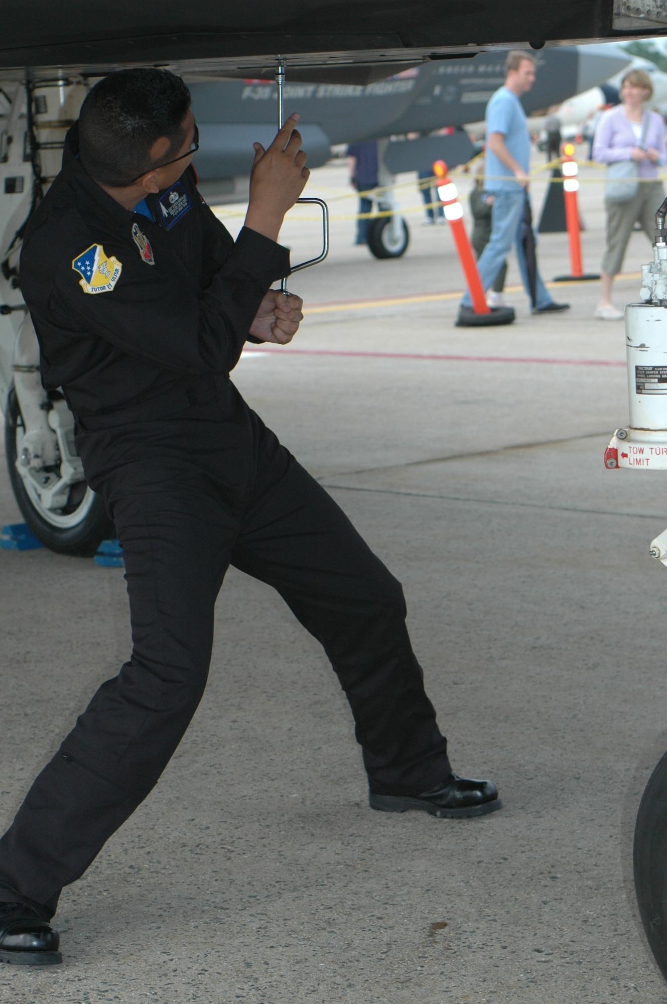 Dedicated Crew Chief Senior Airman Santos Montalvo, a member of the F-117 Demo Team, manually closes the canopy of the F-117 after it failed to work electronically. Troubleshooting problems such as this, oftentimes with a crowd watching on, is one component of being on the demo team. (U.S. Air Force photo by 1st Lt. Phillip Ventura)