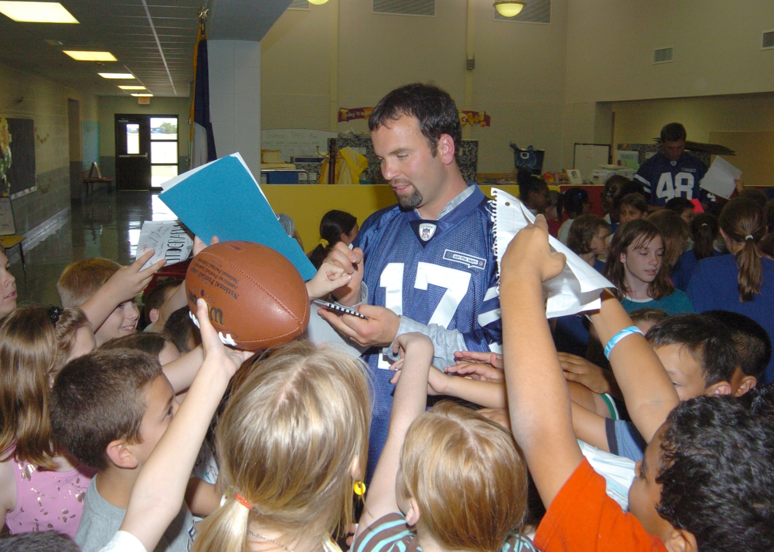 Students at Randolph Elementary School swamp Colts punter Hunter Smith with requests to autograph items during a visit to the base.  Colts players visited Randolph Air Force Base, enhancing relations between the team and the Air Force.  (U.S. Air Force photo by David Terry)