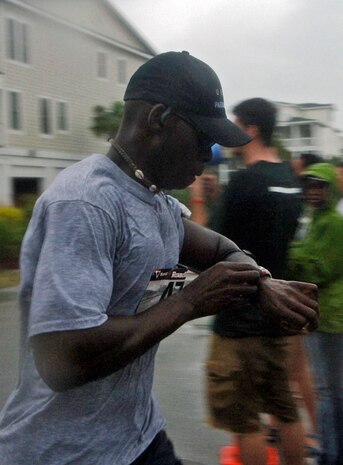 Ramon Brockington, 437th Aircraft Maintenance Squadron, checks his watch for his run time as he perpares to cross the finish line at the ALS New Hope 5K Beach Run  June 2.  (U.S. Air Force photo/Staff Sgt. April Quintanilla)