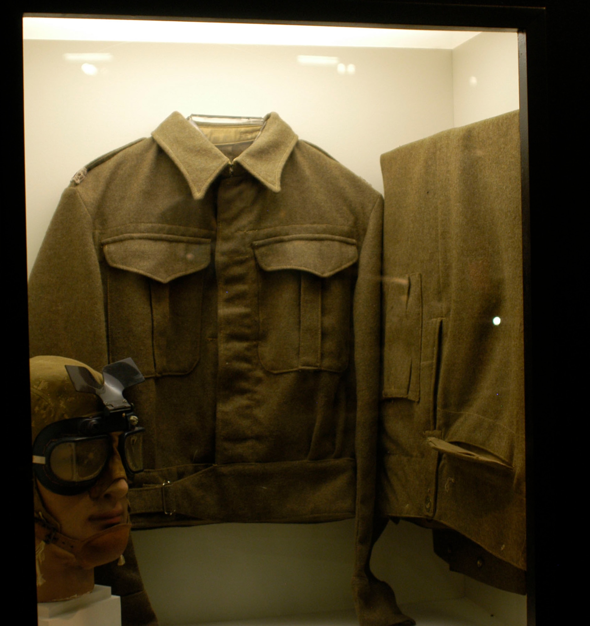 DAYTON, Ohio -- British battle dress and goggles and U.S. flying helmet worn by the donor, Col. Maurice Elstun, on combat missions in North Africa in 1942-1943. When his 93rd Bomb Group was sent from England to Northwest Africa, it was scheduled for only a 10-day period, so most men of the 93rd took few clothes with them. However, the 93rd was soon sent to a base near Torbuk, Libya, for permanent assignment where the only uniforms available were British. These items are on display in the World War II Gallery at the National Museum of the U.S. Air Force. (U.S. Air Force photo)
