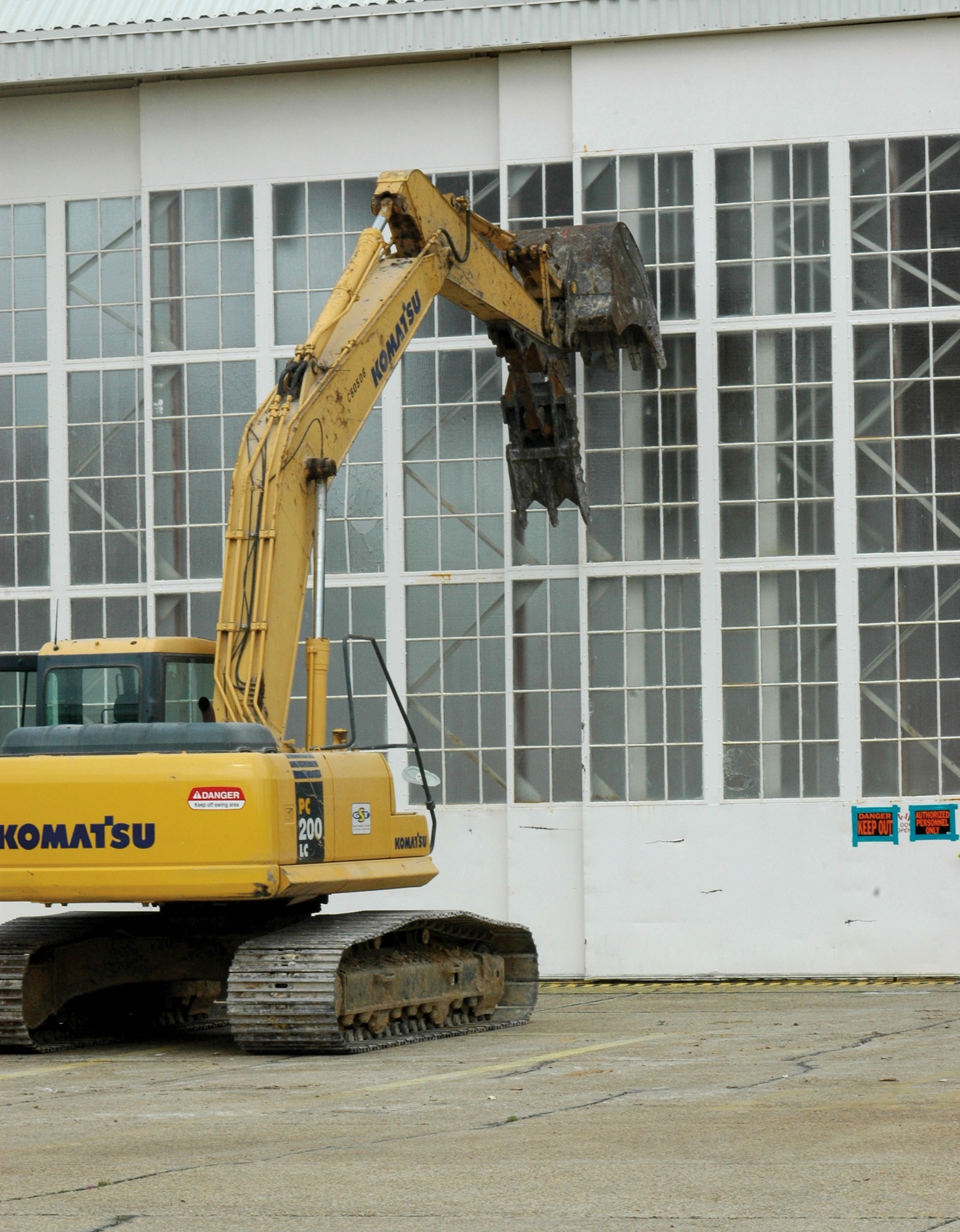 Like a T-Rex, an excavator waits poised to chomp into Hangar 5. The old building was torn down to make way for a state-of-the-art maintenance facility scheduled for ground-breaking in June. (U.S. Air Force Photo/Senior Airman Tabitha Spinks)