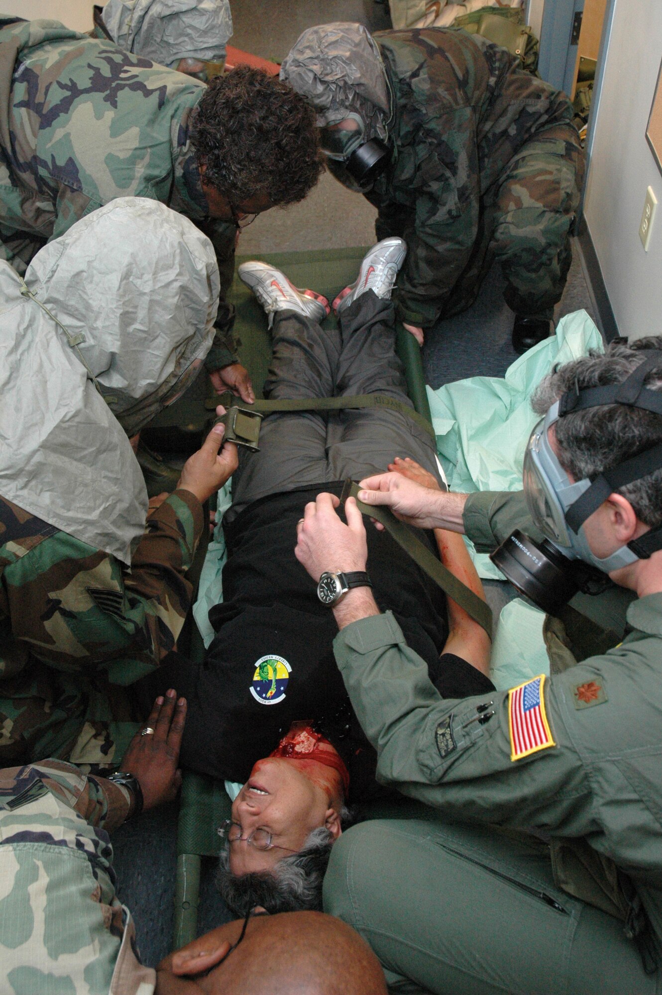 Medics rush to the attention of "patient" Col. Maria de los Pons, coomander, 403rd ASTS, during an exercise designed to help prepare the unit for upcoming inspections. Colonel Pons was made up with moulage simulating a serious neck injury. While wearing their chemical protective gear, the troops had to determine what her injuries were and provide immediate assistance. (U.S. Air Force Photo/Staff Sgt. Michael Eaton)
