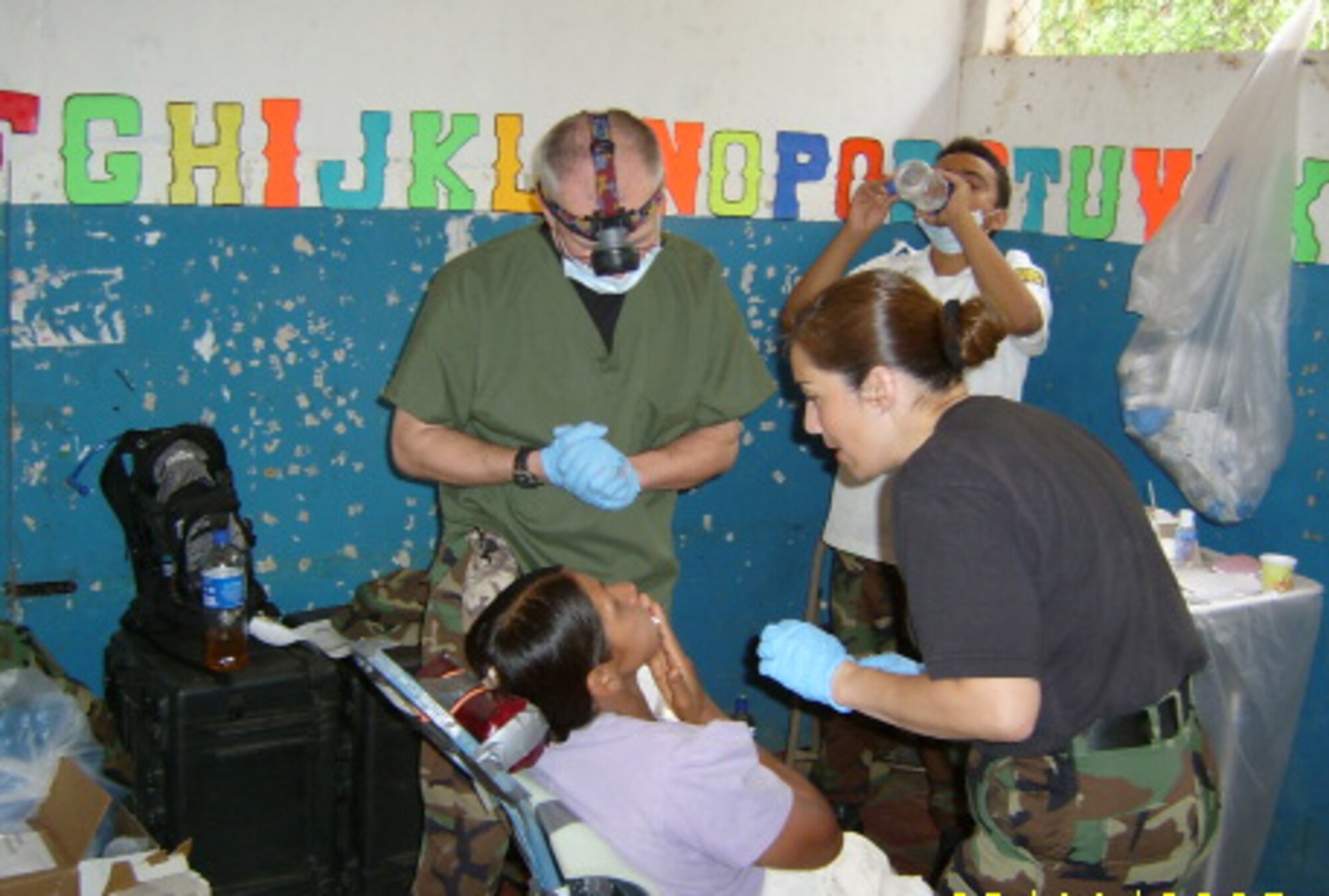 Staff Sgt. Jenny Bakopoulos (right), a reservist with the 315th AMDS, Charleston AFB, S.C., assists Lt. Col. (Doctor) Victor Brown from the 914th ASTS, Niagara Falls IAP, N.Y., as they treat a patient in El Salvador.  (USAF Photo)