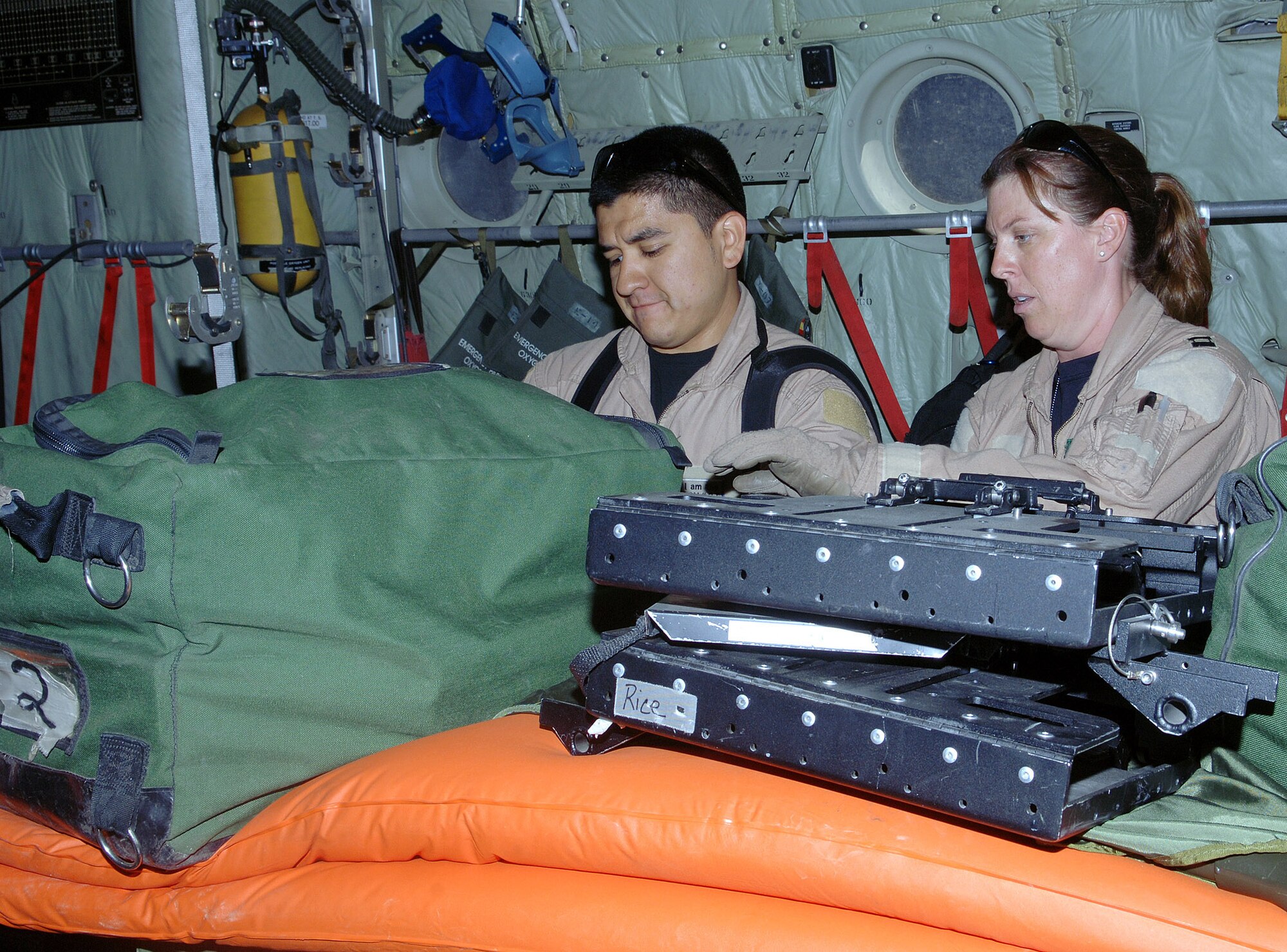 Senior Airman Roy Aguilar (left), critical care air transport team respiratory therapist, and Capt. Jenna Jamison, CCATT intensive care nurse, inventory and prep their equipment aboard a C-130 prior to a mission at Bagram Airfield, Afghanistan. Airman Aguilar and Capt. Jamison are deployed from Wilford Hall Medical Center, Lackland Air Force Base, Texas. (photo by Staff Sgt. Craig Seals) 