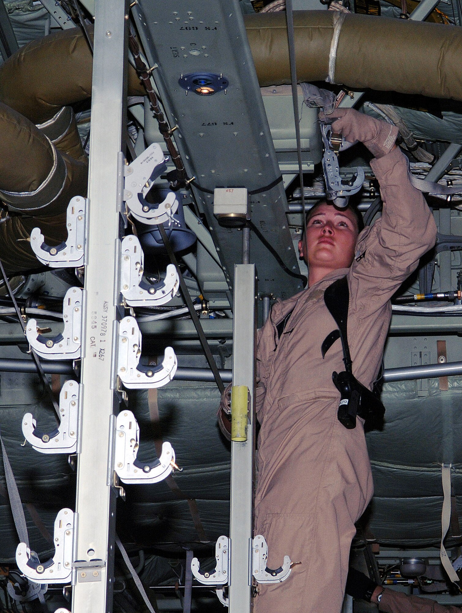 Senior Airman Amber O'Neil, 455th Expeditionary Aeromedical Evacuation Flight medical technician, prepares straps to attach litter patients on a C-130 prior to a mission at Bagram Airfield, Afghanistan. Airman O'Neil is deployed from the 153rd Airlift Wing, Wyoming Air National Guard. (photo by Staff Sgt. Craig Seals)