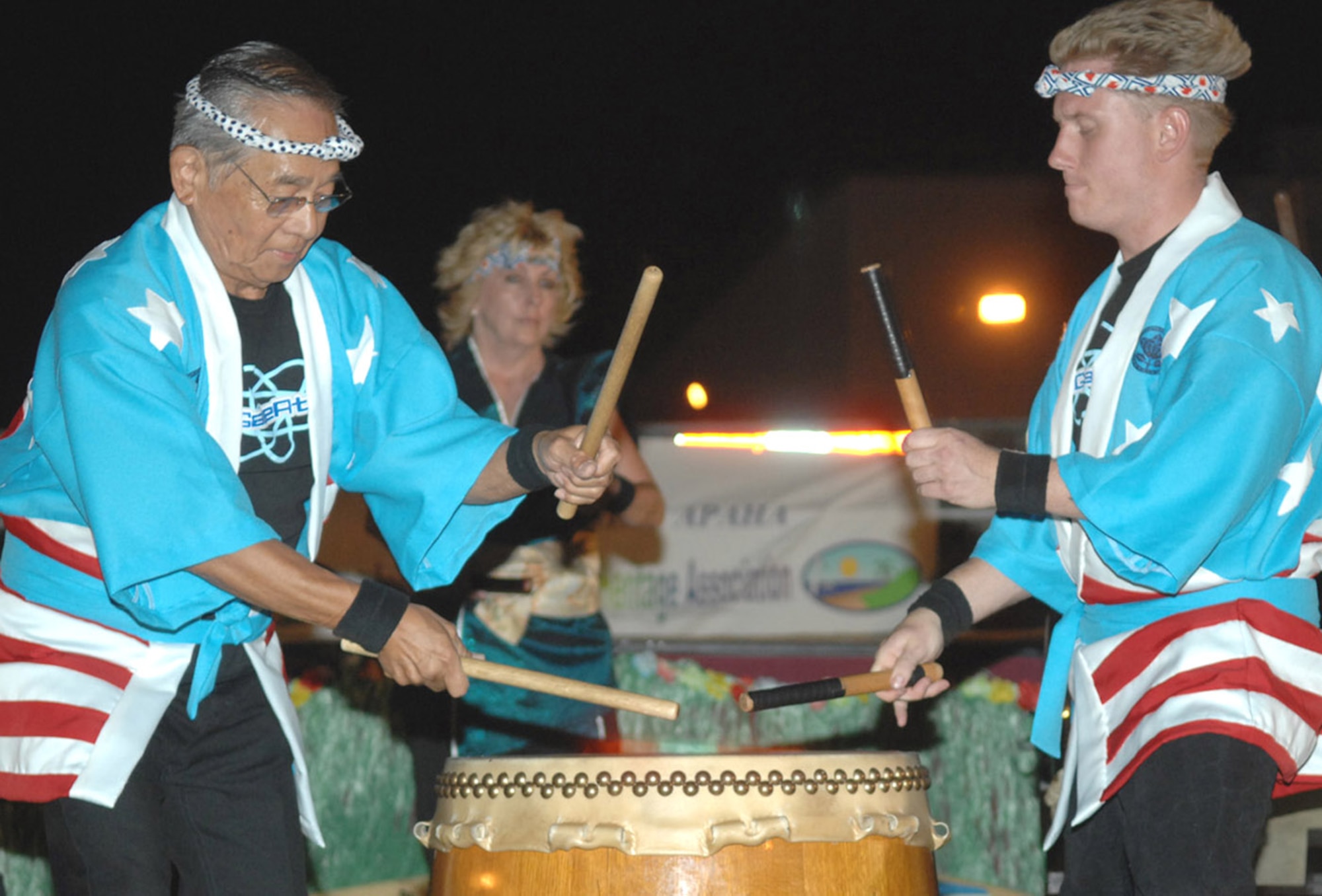 Kenji Azeka (left) and Nick Ballinger, both members of Suzuyuki-Kai MoGan Daiko, perform Taiko drumming to represent the culture of Japan during the Asian/Pacific American Heritage Luau at Bama Park here June 1. (U.S. Air Force photo/Senior Airman Christina D. Ponte)