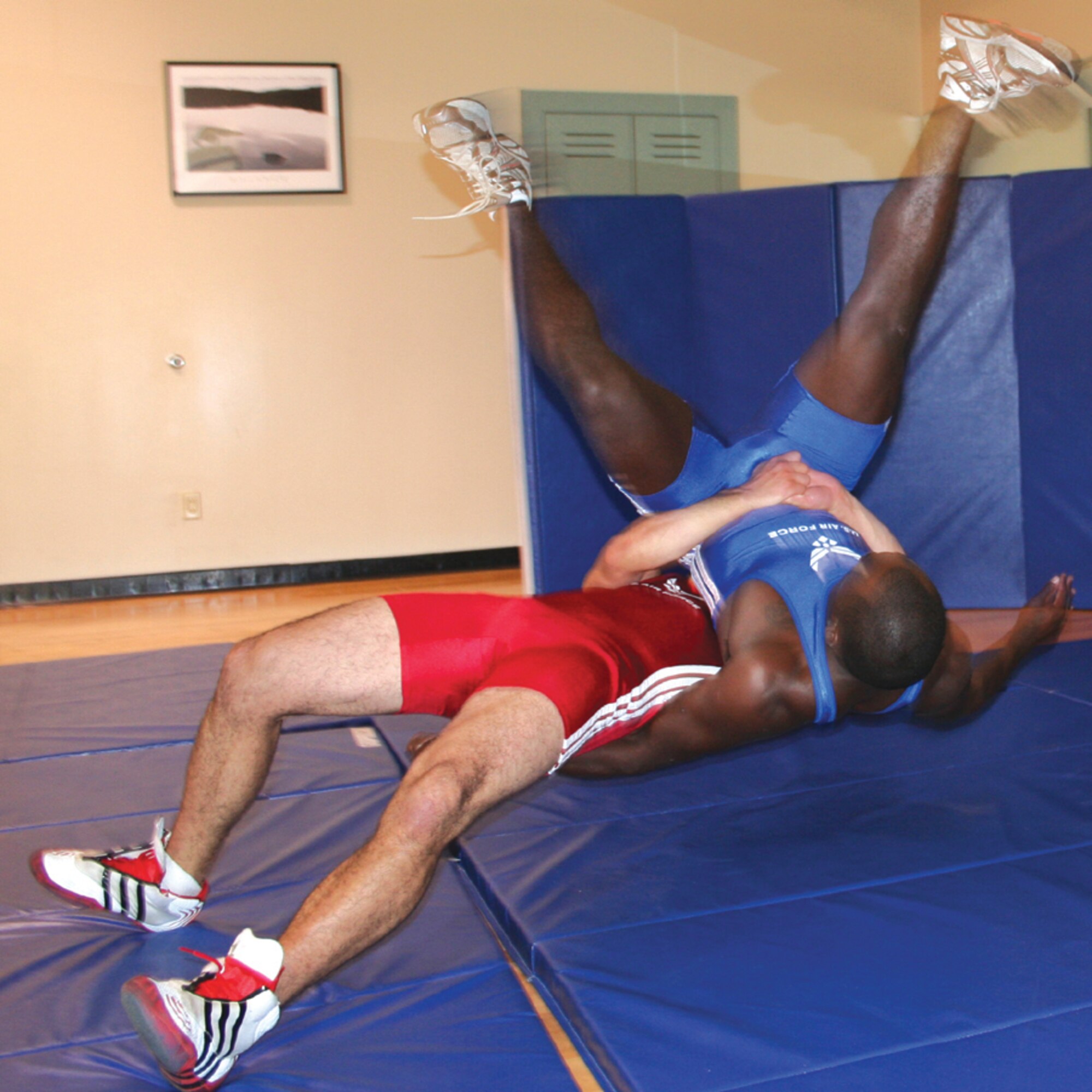 Senior Airman Christopher Anderson (in red), 720th Operations Support Squadron, practices his wrestling moves on a fellow combat controller Tuesday at the Riptide Fitness Center. Airman Anderson has already taken on the Greco-Roman wrestling world at Air Force and national levels. Now, he is in training to try out for the 2008 Olympic wrestling team. (U.S. Air Force photo by 2nd Lt. Jesse Brannen)