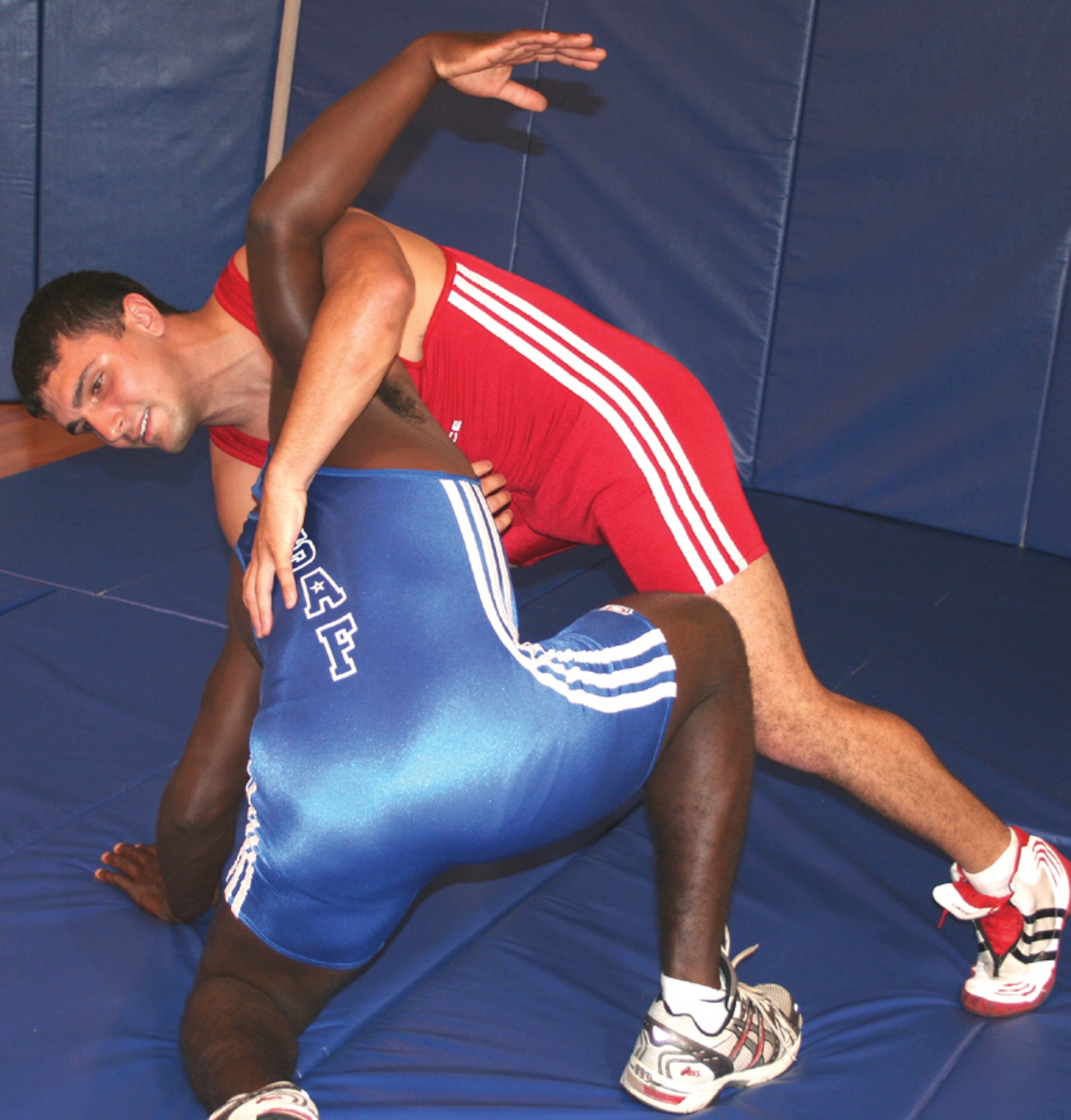 Senior Airman Christopher Anderson (in red), 720th Operations Support Squadron, practices his wrestling moves on a fellow combat controller Tuesday at the Riptide Fitness Center. Airman Anderson has already taken on the Greco-Roman wrestling world at Air Force and national levels. Now, he is in training to try out for the 2008 Olympic wrestling team. (U.S. Air Force photo by 2nd Lt. Jesse Brannen)