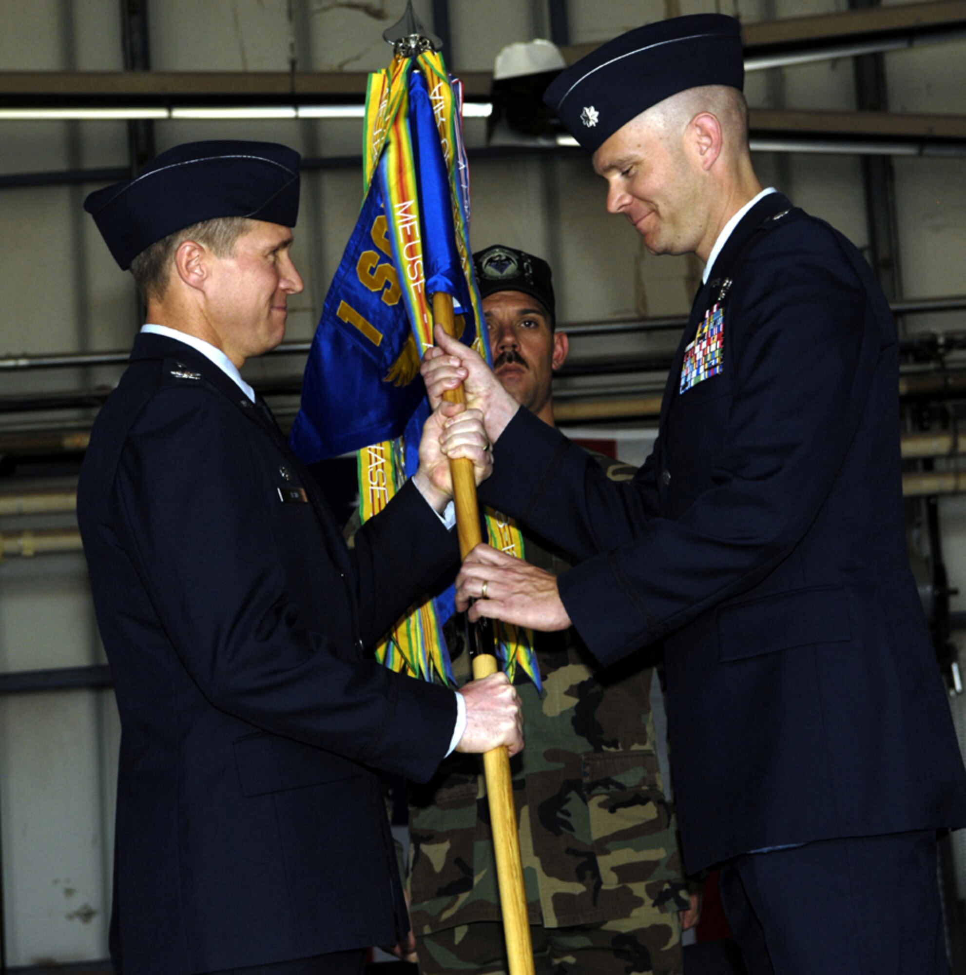 Col. Mark Alsid, 1st Special Operations Group commander, passes the 3rd Special Operations Squadron guidon to Lt. Col. Paul Caltagirone, as he assumes command of the squadron May 31. (U.S. Air Force photo by Staff Sgt. Orly Tyrell)