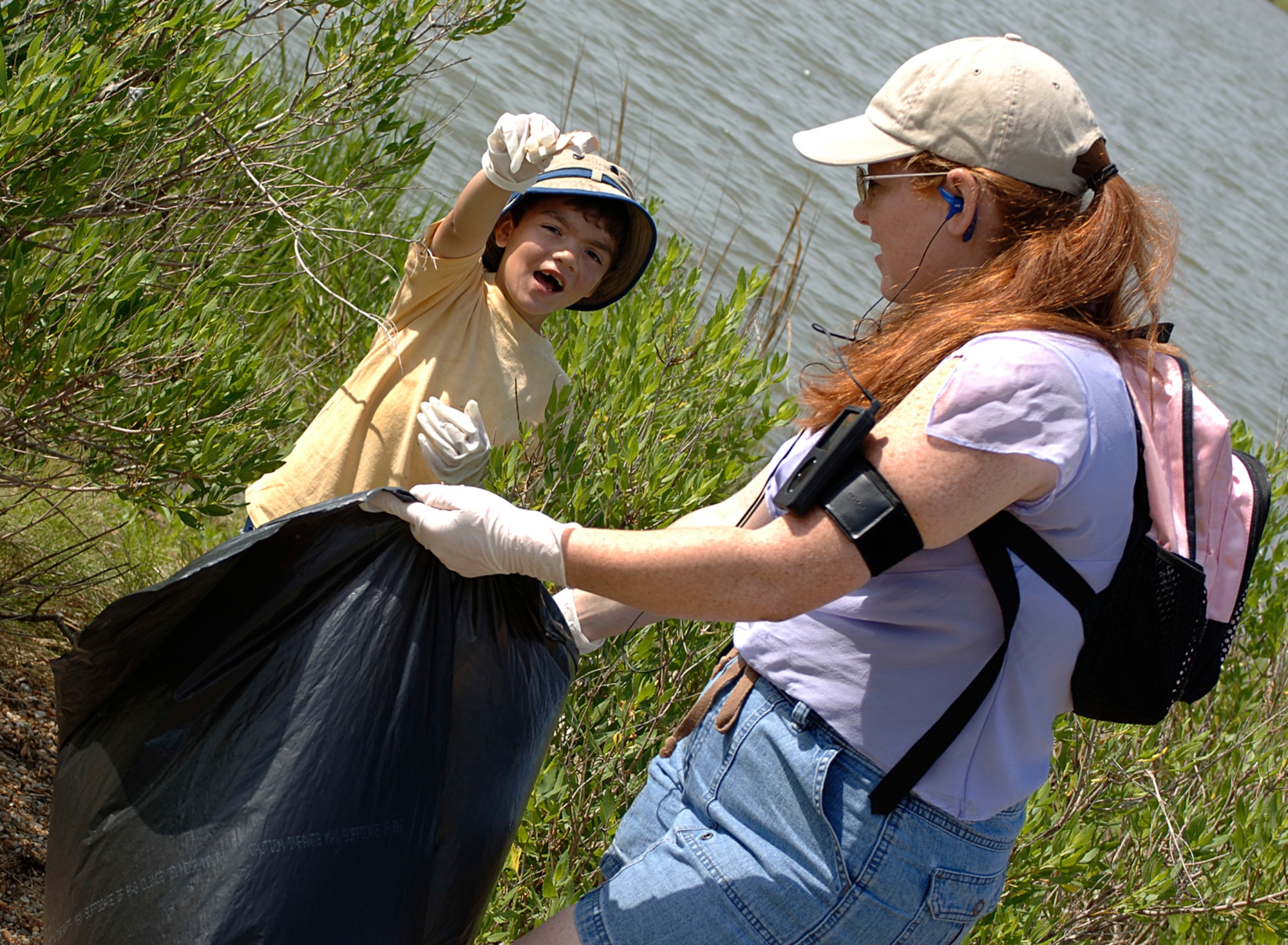 Alexandria Valdez and her son, Diego, pick up trash during the 19th Annual Clean the Bay Day at Eagle Park here June 2. More than 150 volunteers cleaned up the Langley shoreline of the Chesapeake Bay, collecting more than 3 tons of waste. (U.S. Air Force photo/Airman 1st Class Scott Aldridge)